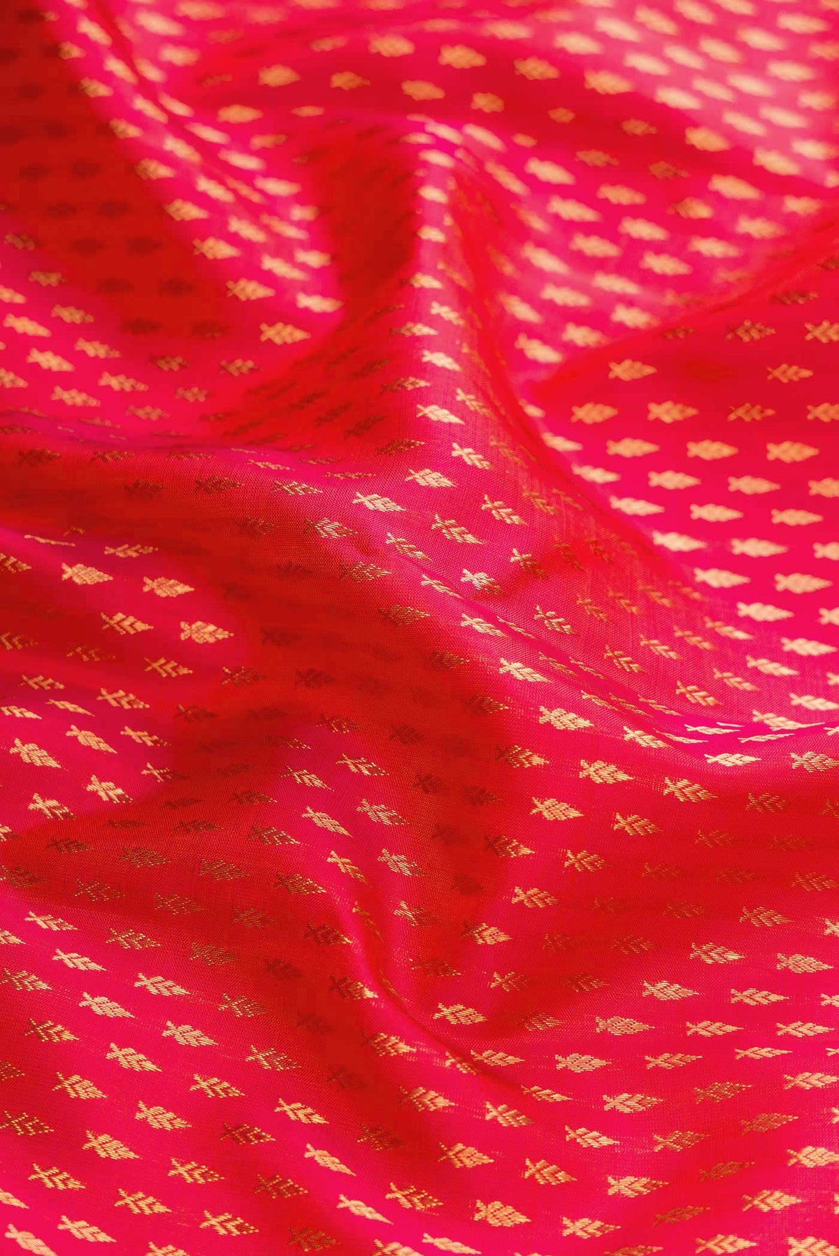 Close up of Pink Kanchipuram Silk Saree with Zari Butta on the body and Zari Border displaying folds