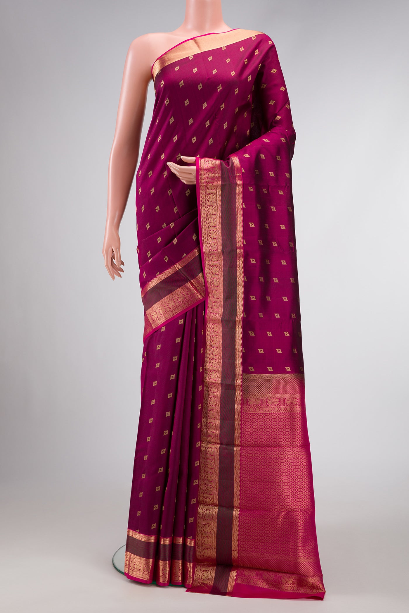 Magenta Dual Tone Kanchipuram Silk Saree with Zari Butta on the body and Zari Border.  displayed on a mannequin
