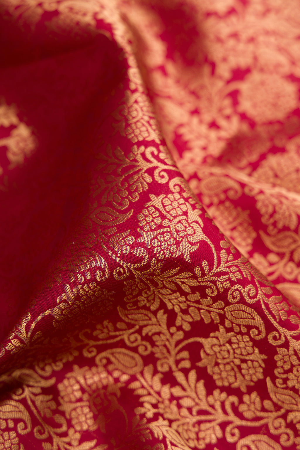Close up of Maroon Kanchipuram Silk Saree with Zari Brocade on the body and Zari Border.  displaying folds
