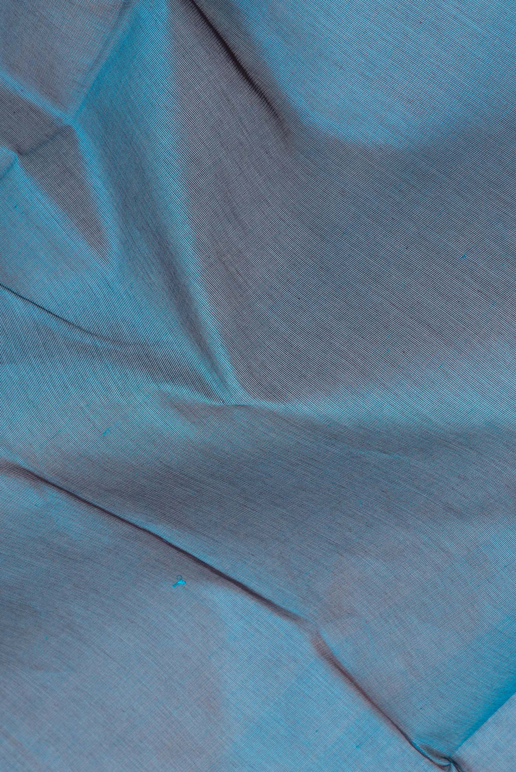 Close up of Peacock Blue Silk Cotton Saree with Plain Body and Zari Border.  displaying folds