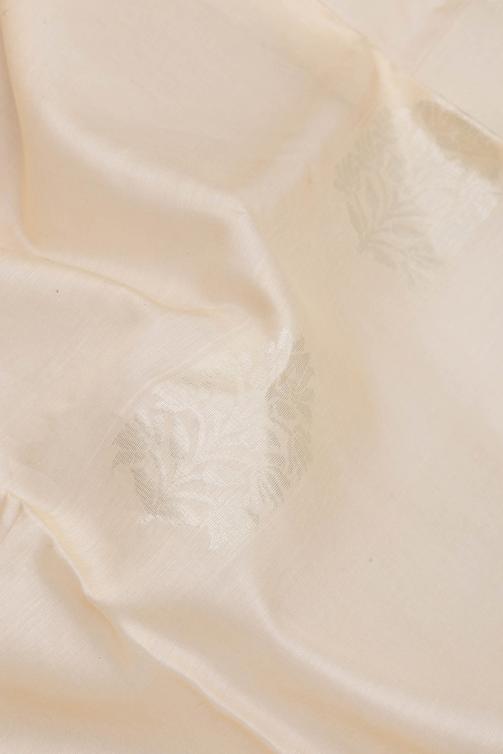 Close up of Off White Silk Cotton Saree with Zari Butta on the body and Zari Border.  displaying folds