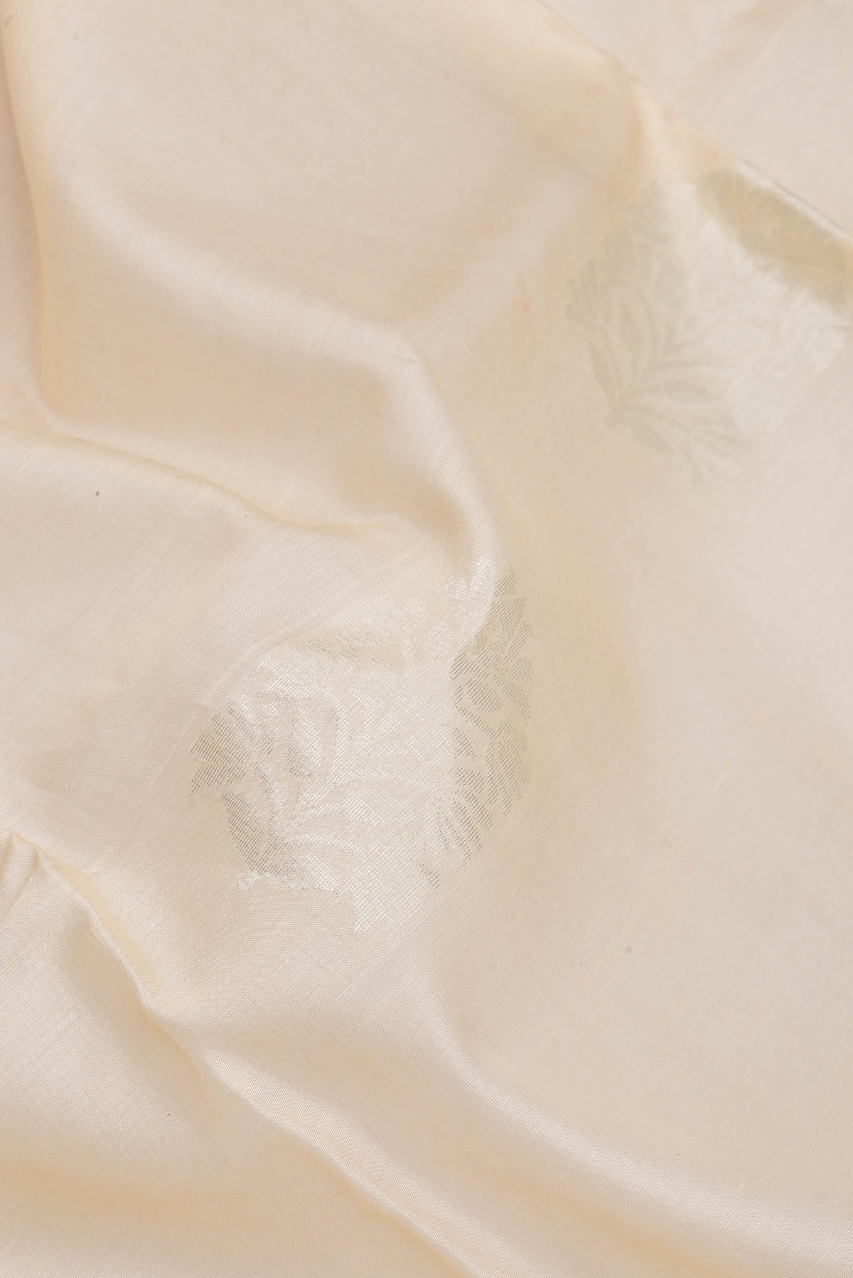 Close up of Off White Silk Cotton Saree with Zari Butta on the body and Zari Border.  displaying folds