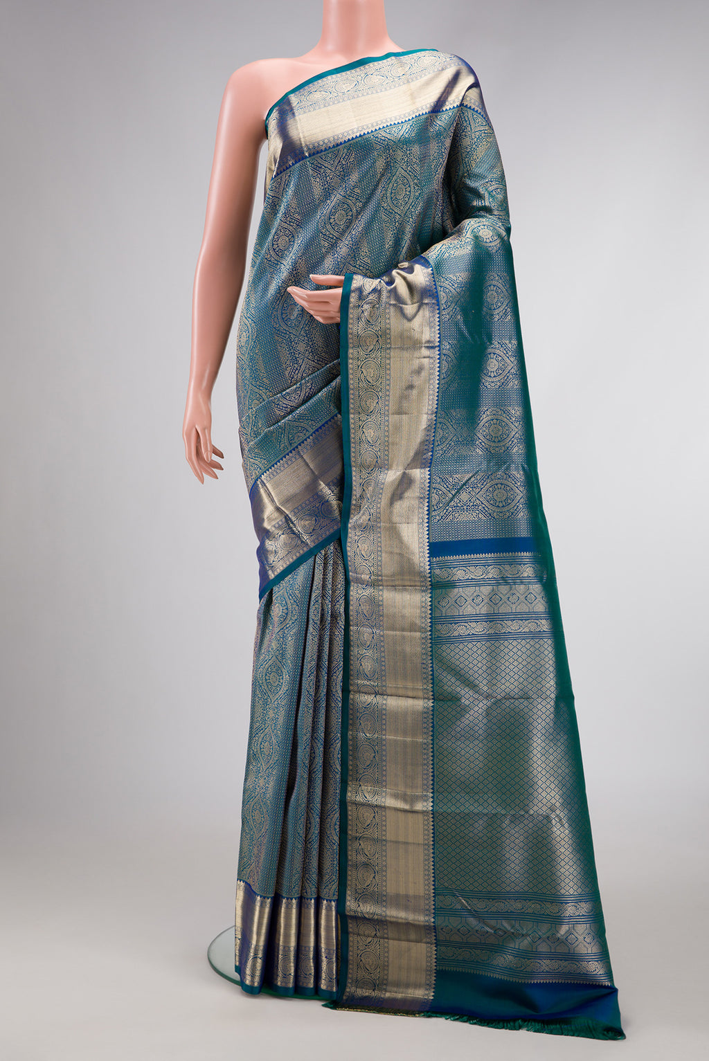 Peacock Blue Dual Tone Kanchipuram Silk Saree with Zari Brocade on the body and Zari Border.  displayed on a mannequin