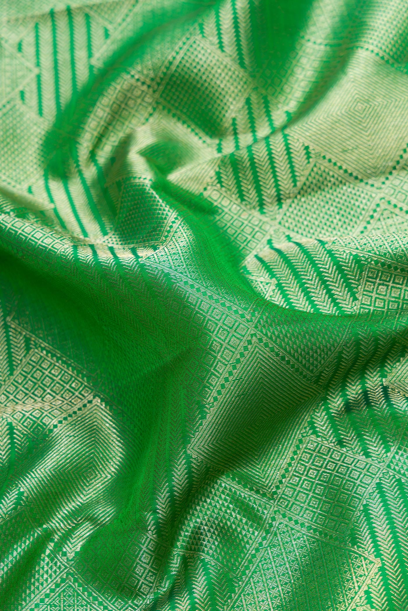 Close up of Green Dual Tone Kanchipuram Silk Saree with Zari Brocade on the body and Zari Border.  displaying folds