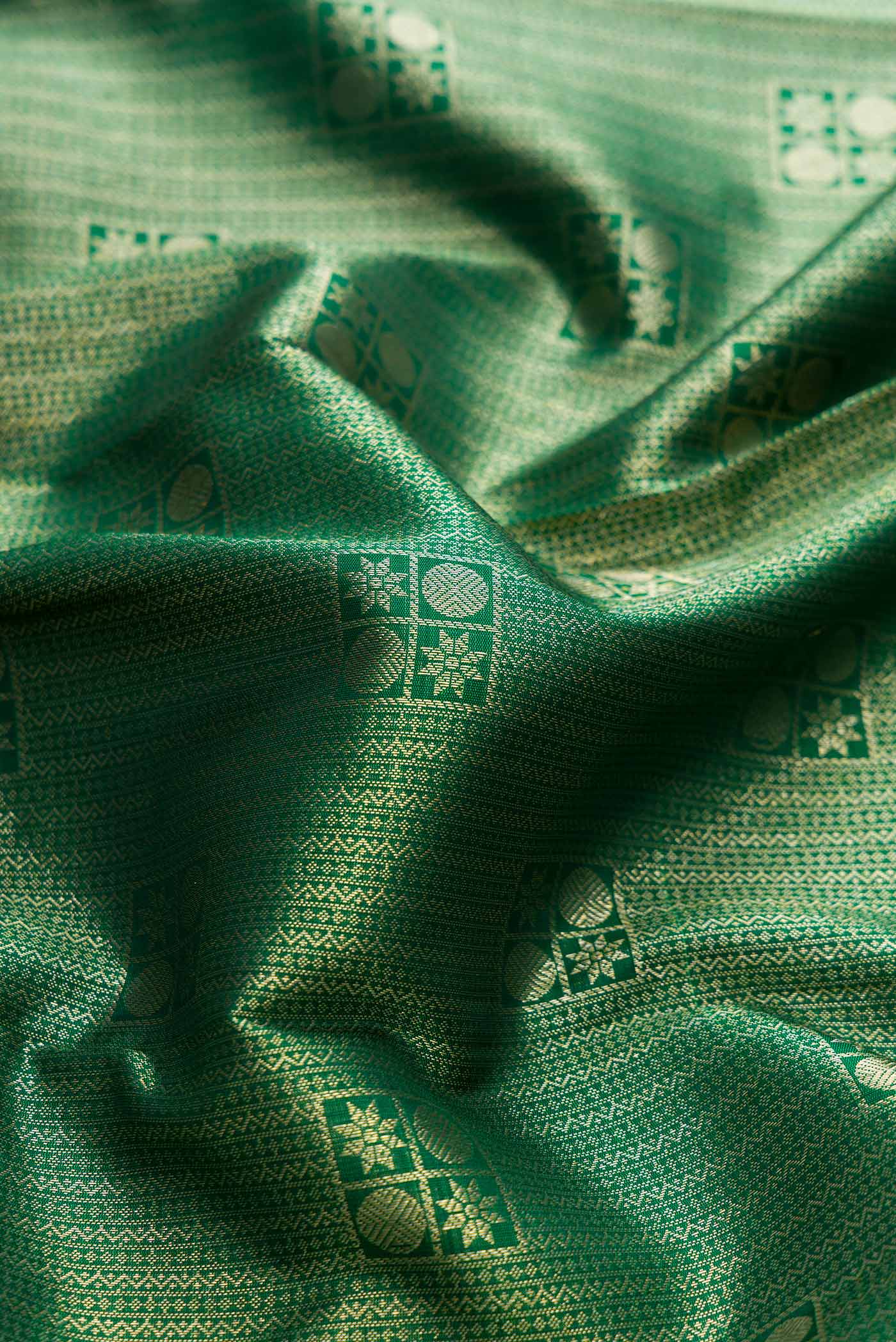 Close up of Green Dual Tone Kanchipuram Silk Saree with Zari Brocade on the body and Zari Border displaying folds