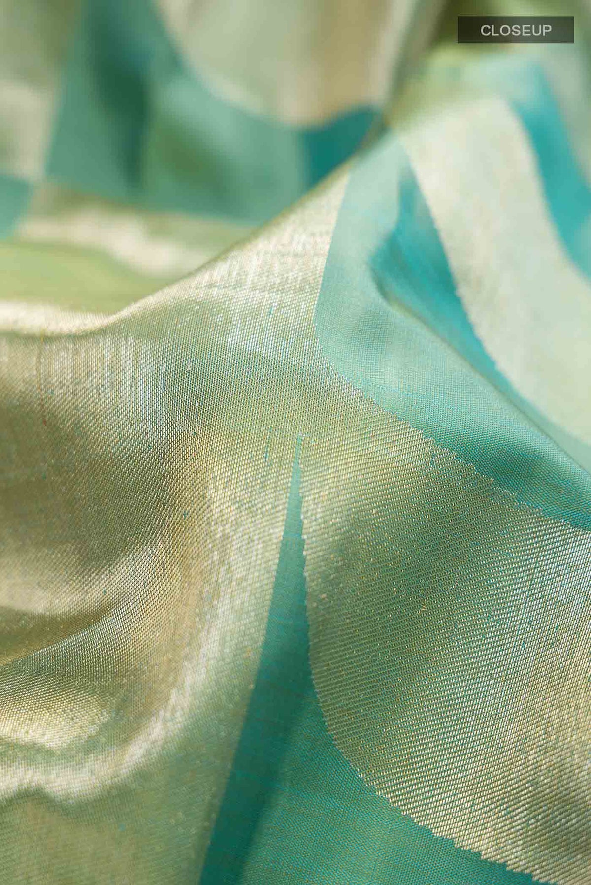 Close up of Green Kanchipuram Silk Saree with Zari Butta on the body and Zari Border displaying folds