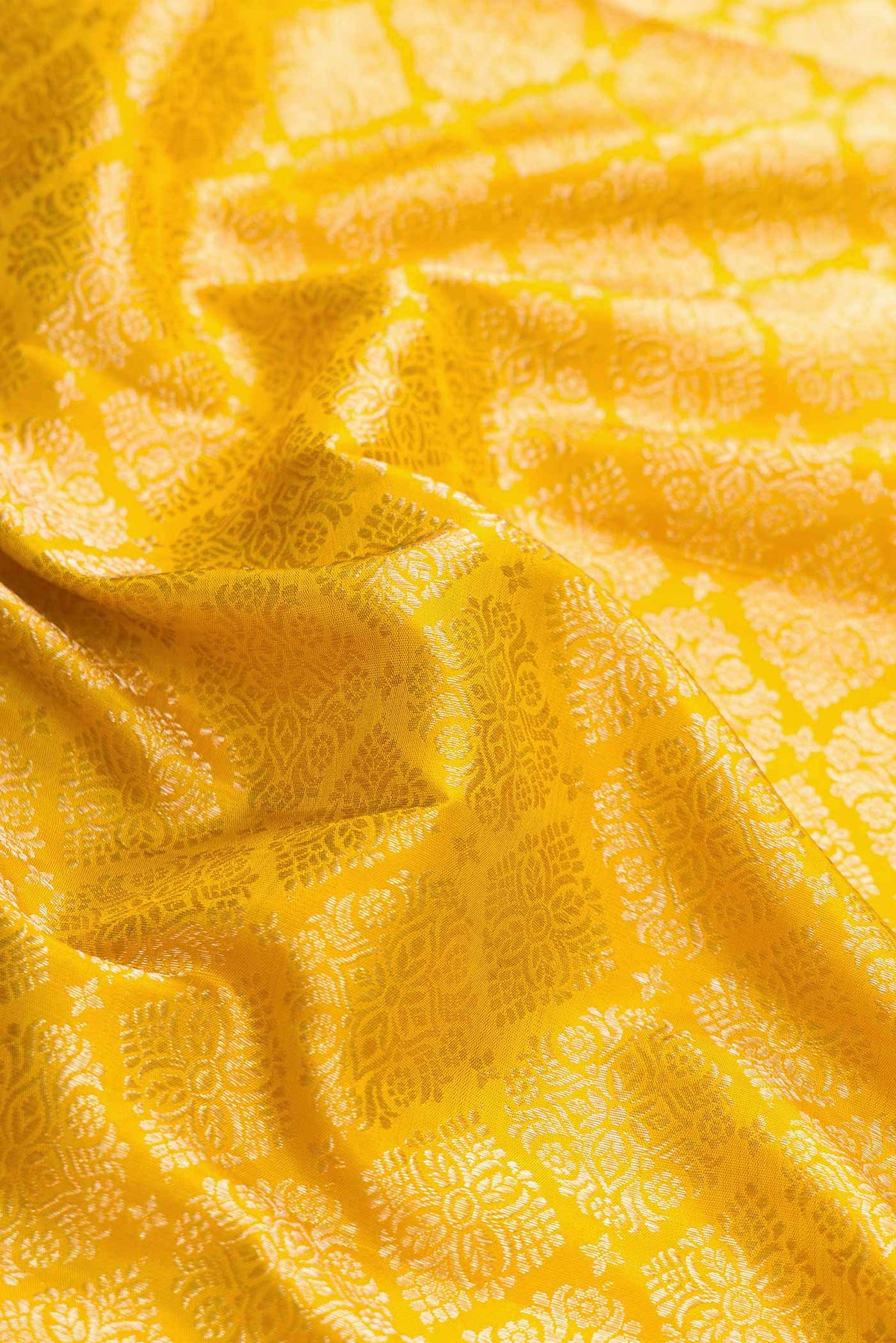 Close up of Mustard Dual Tone Kanchipuram Silk Saree with Zari Brocade on the body and Zari Border displaying folds