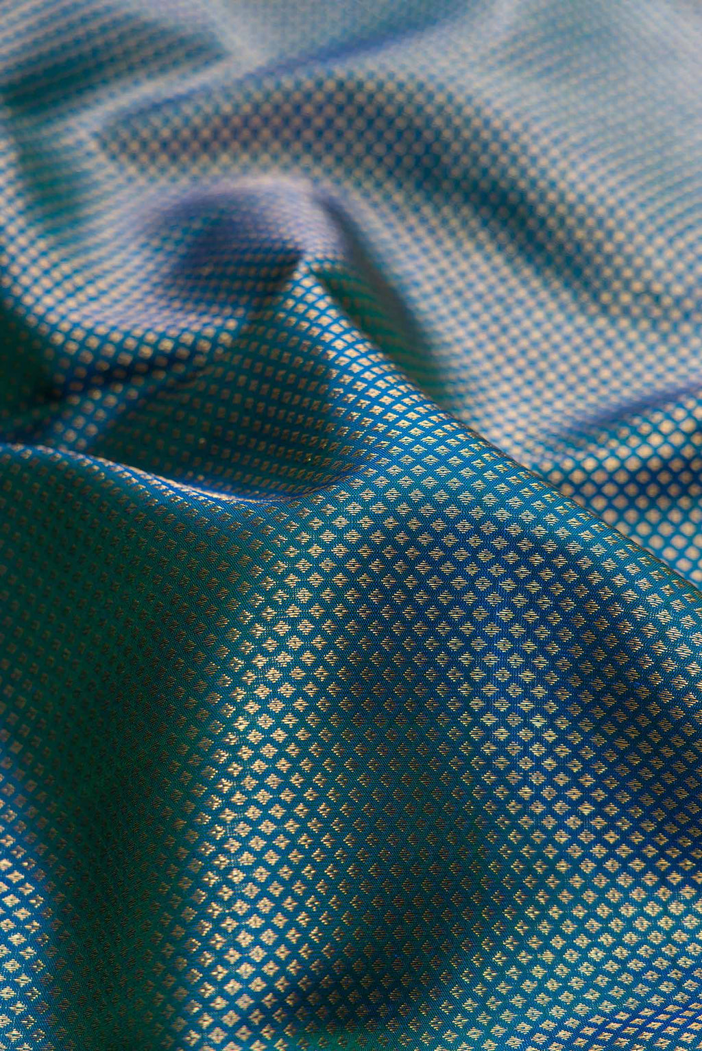 Close up of Peacock Blue Dual Tone Kanchipuram Silk Saree with Zari Brocade on the body and Zari Border.  displaying folds