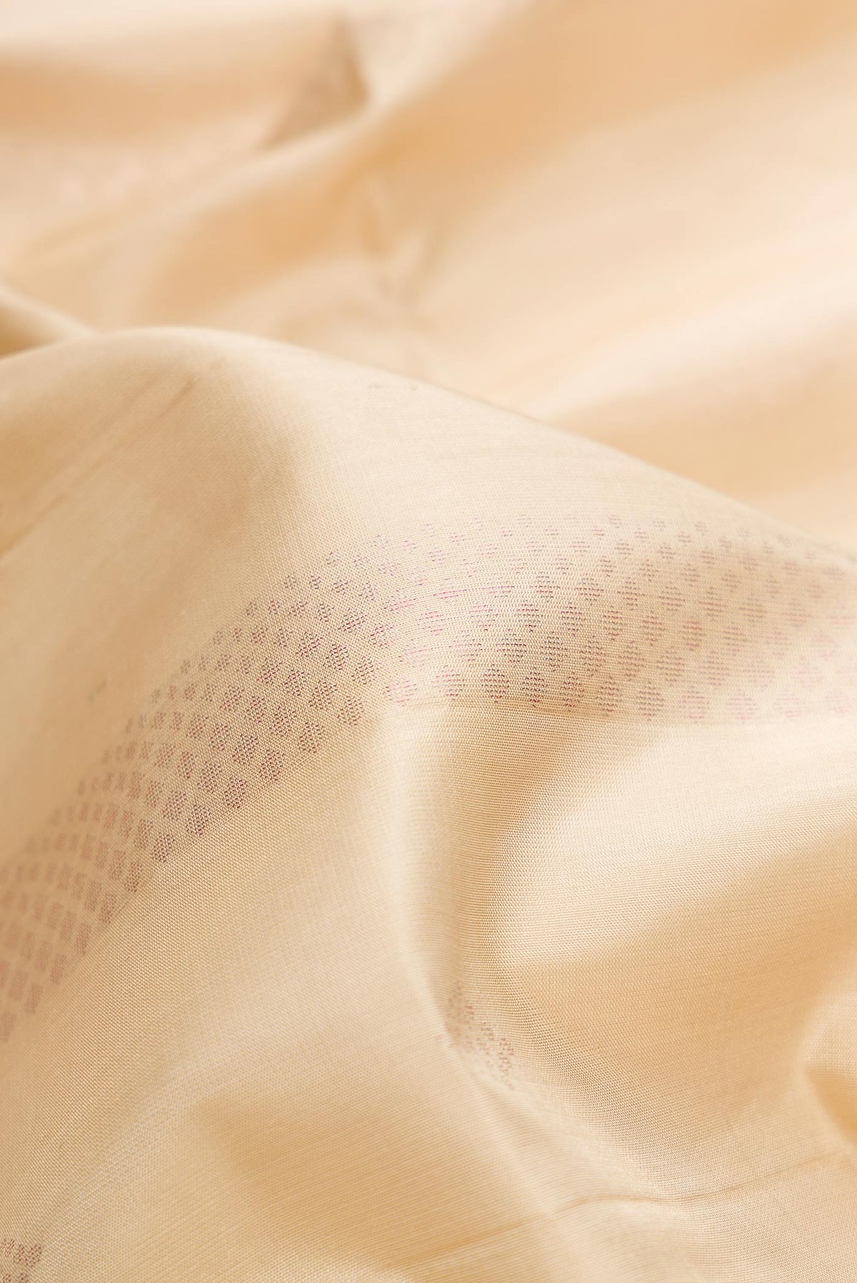 Close up of Beige Dual Tone Soft Silk Saree with Zari Butta on the body and Zari Border.  displaying folds