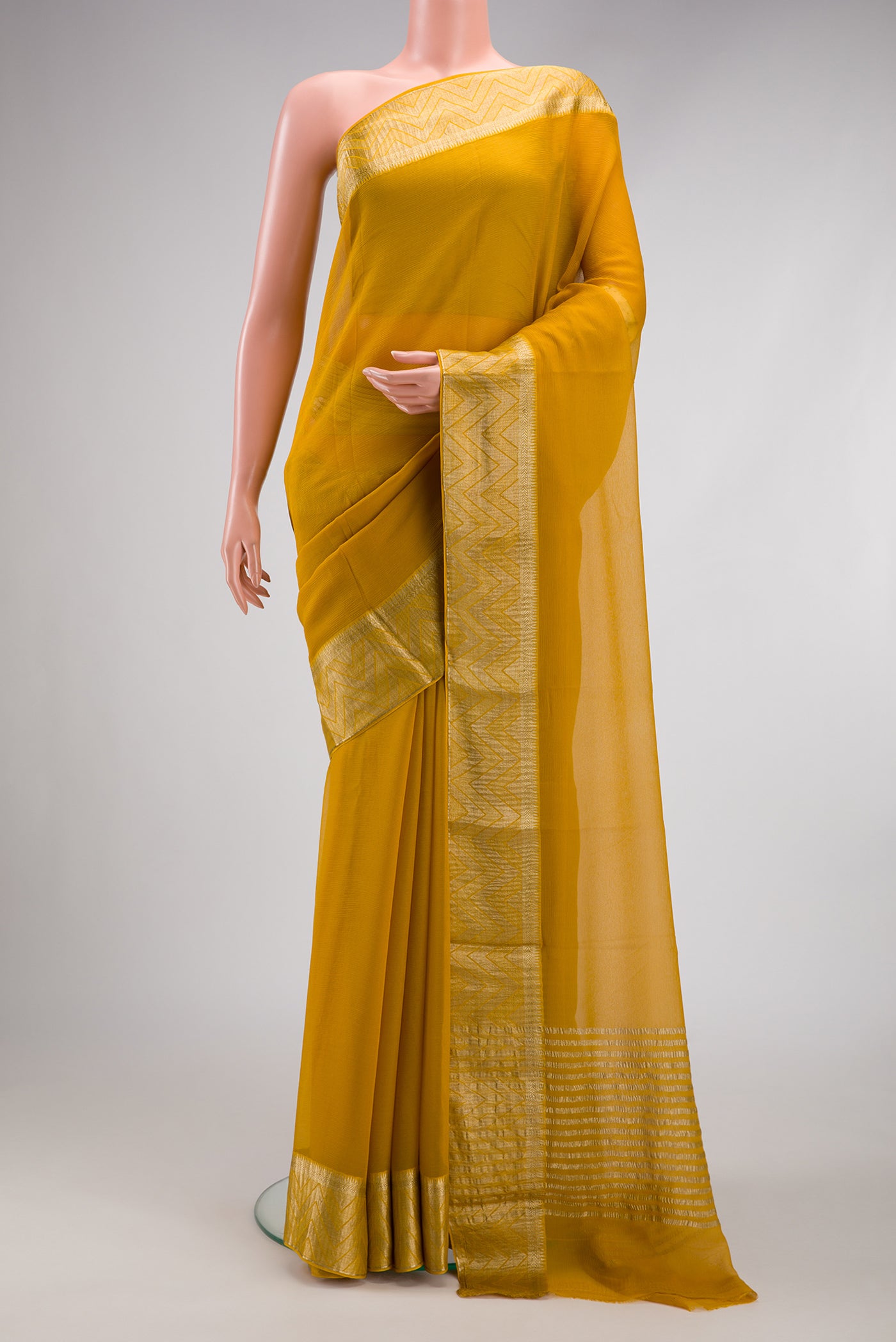 Mustard Mysore Chiffon Saree with Plain Body and Zari Border.  displayed on a mannequin
