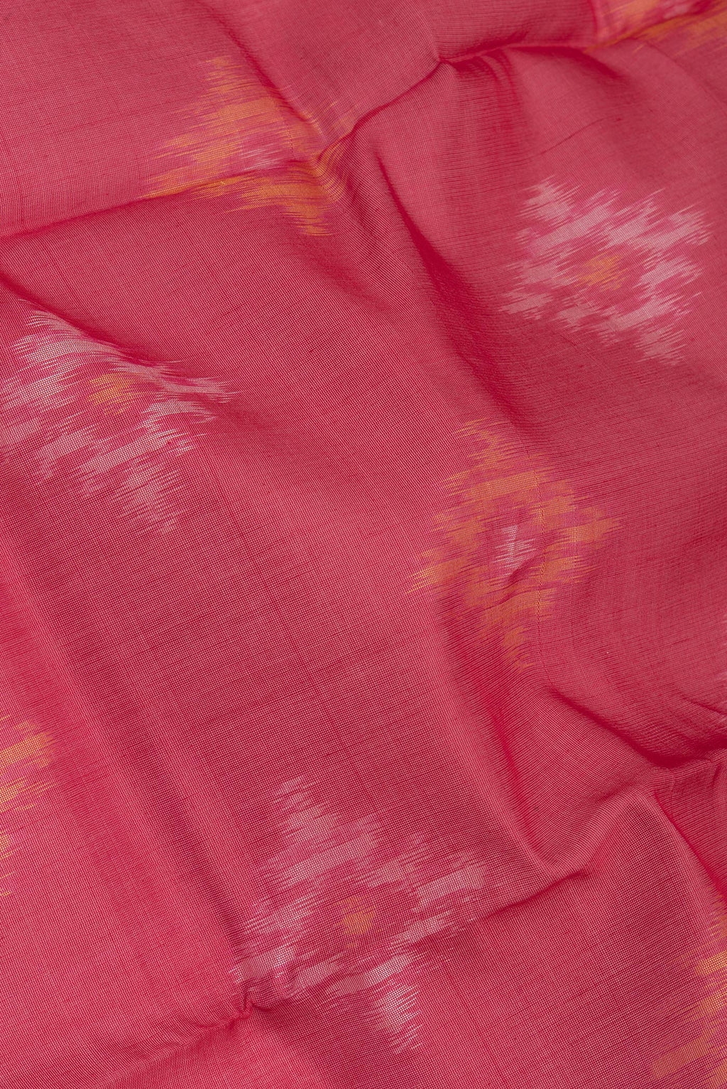 Close up of Red Silk Cotton Saree with Ikat Print on the body and Zari Border.  displaying folds