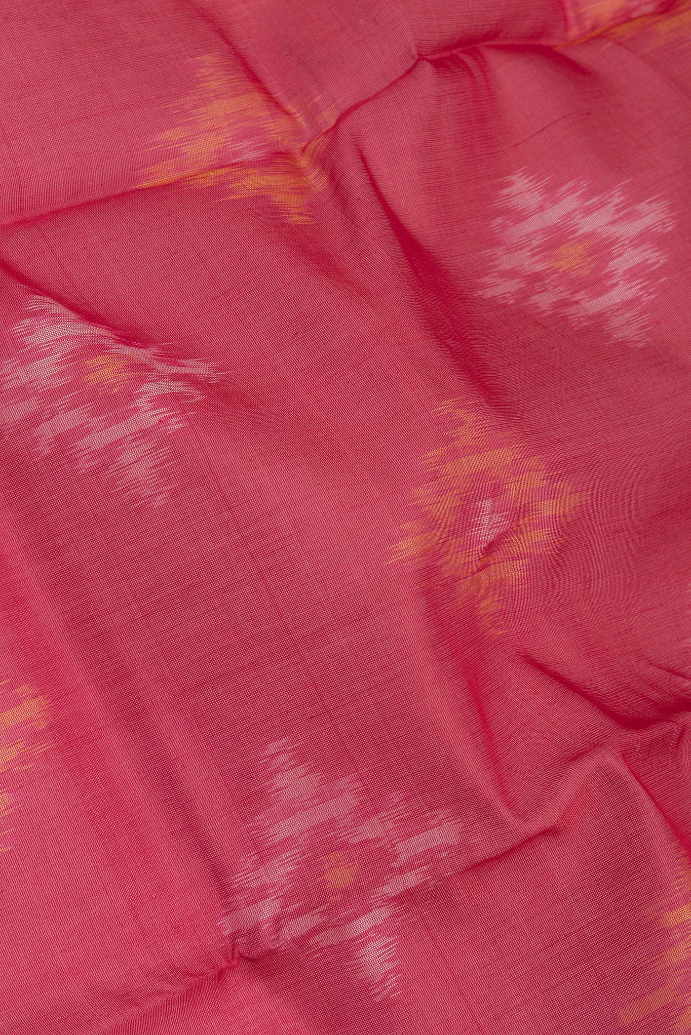 Close up of Red Silk Cotton Saree with Ikat Print on the body and Zari Border.  displaying folds