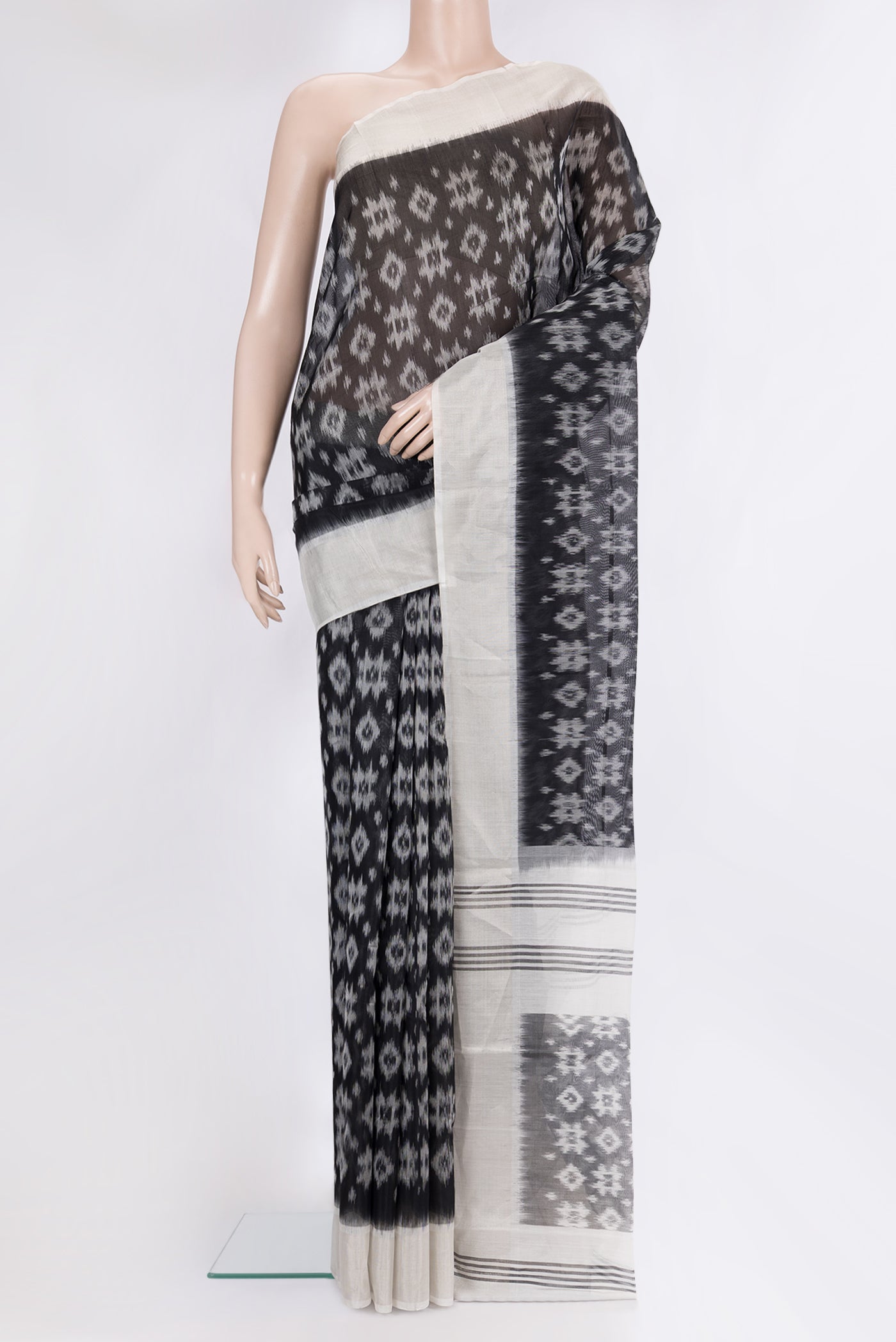 Black Silk Cotton Saree with Ikat Print on the body and Zari Border.  displayed on a mannequin