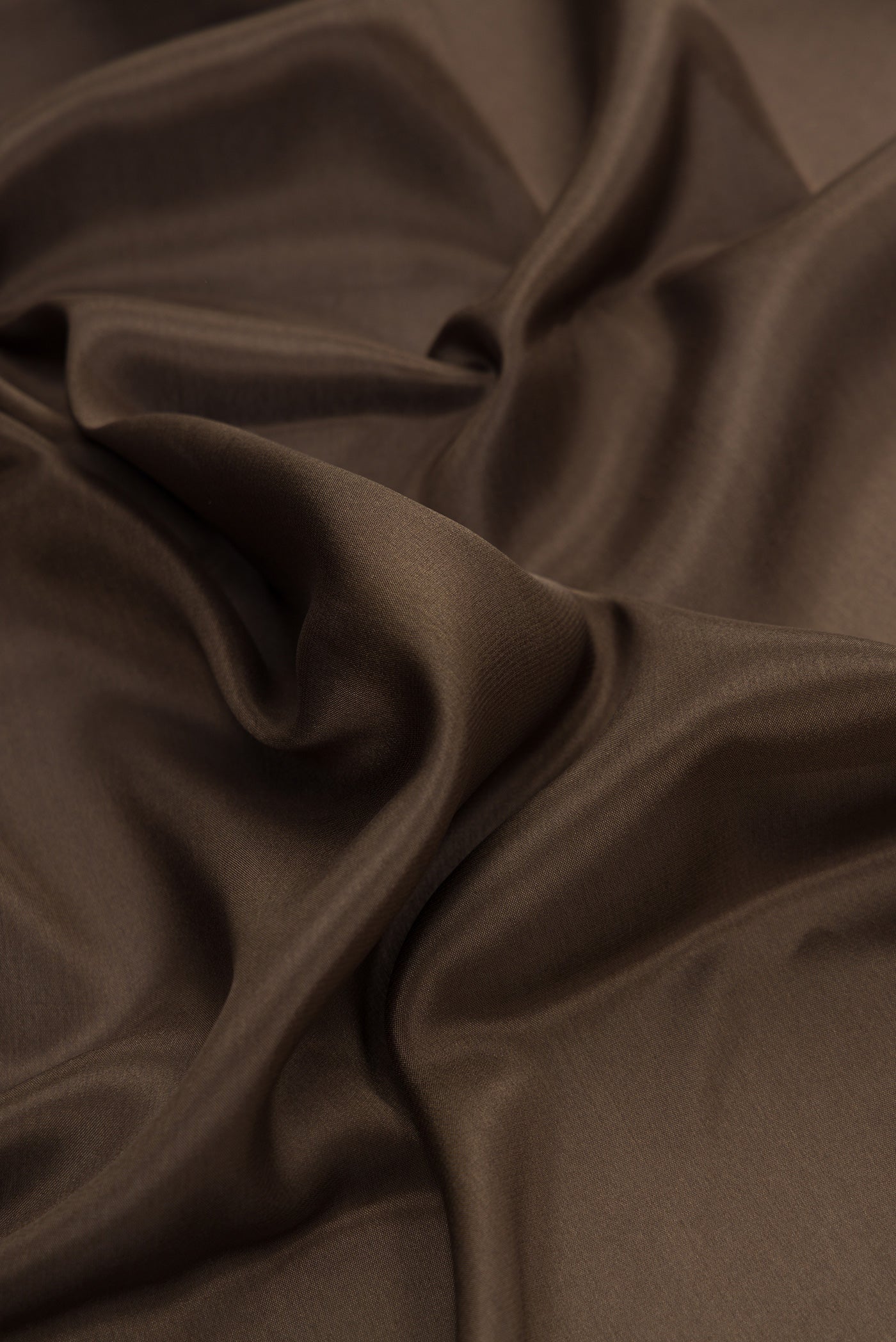 Close up of Brown Dual Tone Mysore Silk Saree with Plain Body and Zari Border.  displaying folds