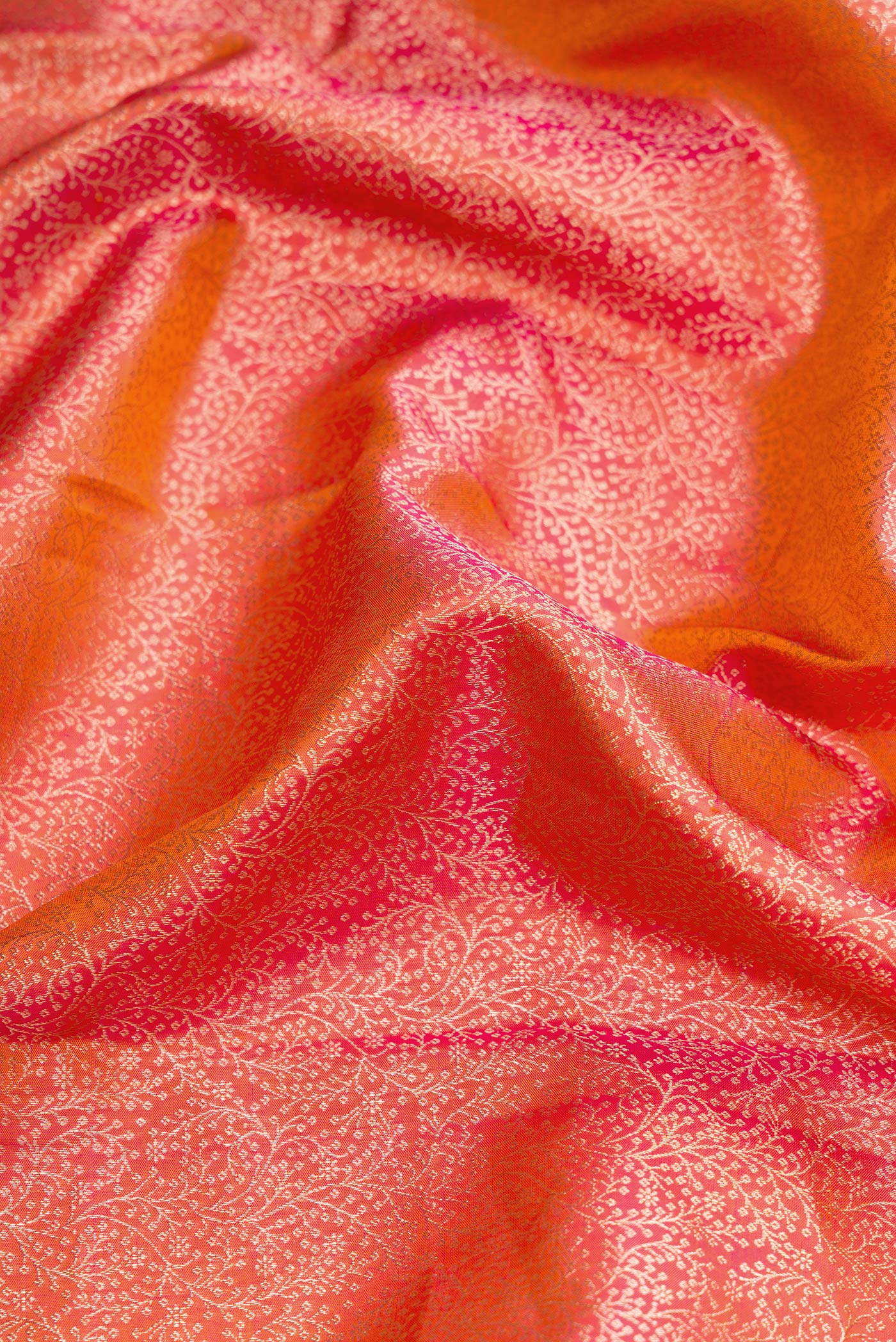 Close up of Coral Dual Tone Kanchipuram Silk Saree with Zari Brocade on the body and Zari Border.  displaying folds
