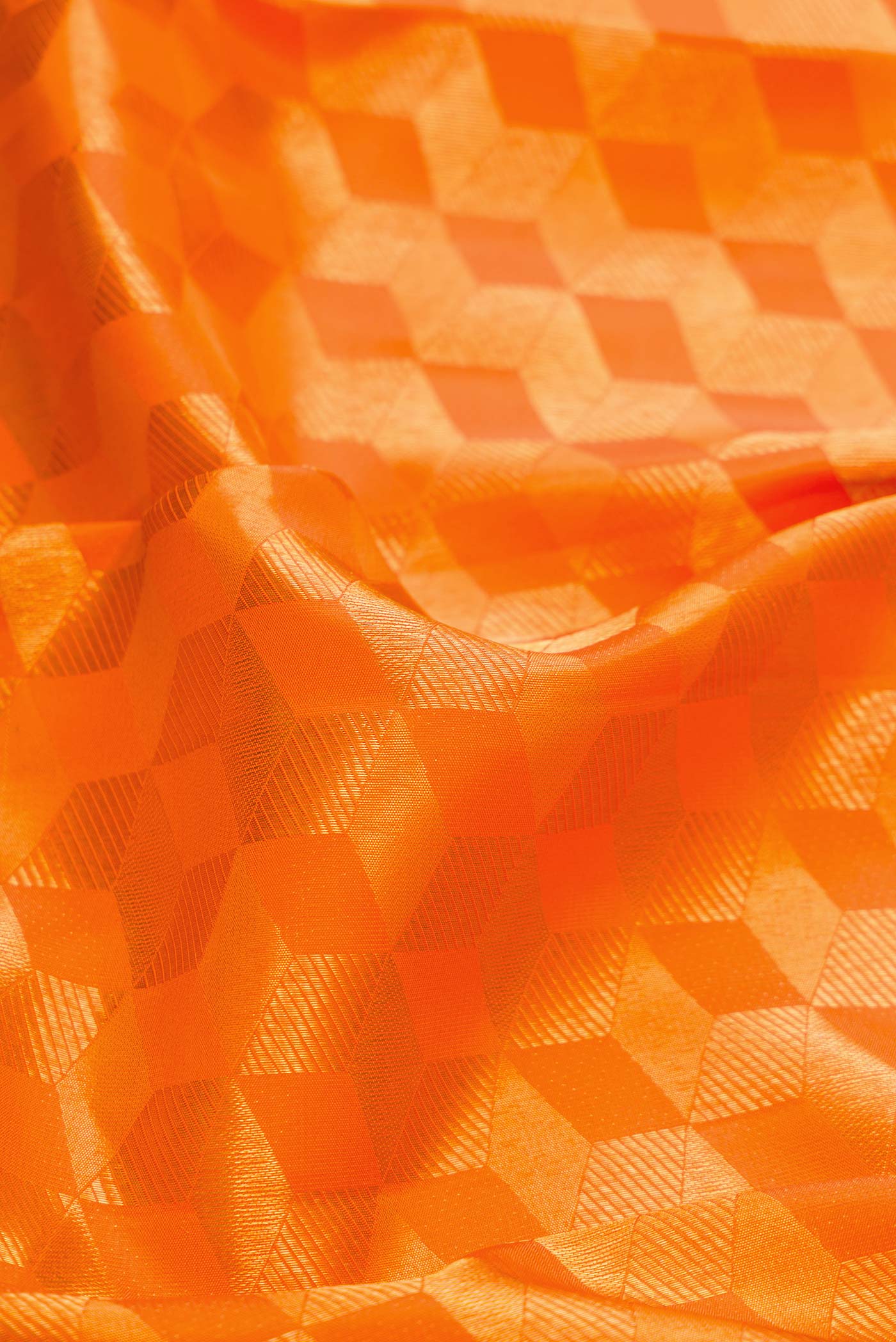 Close up of Orange Dual Tone Kanchipuram Silk Saree with Zari Brocade on the body and Zari Border displaying folds