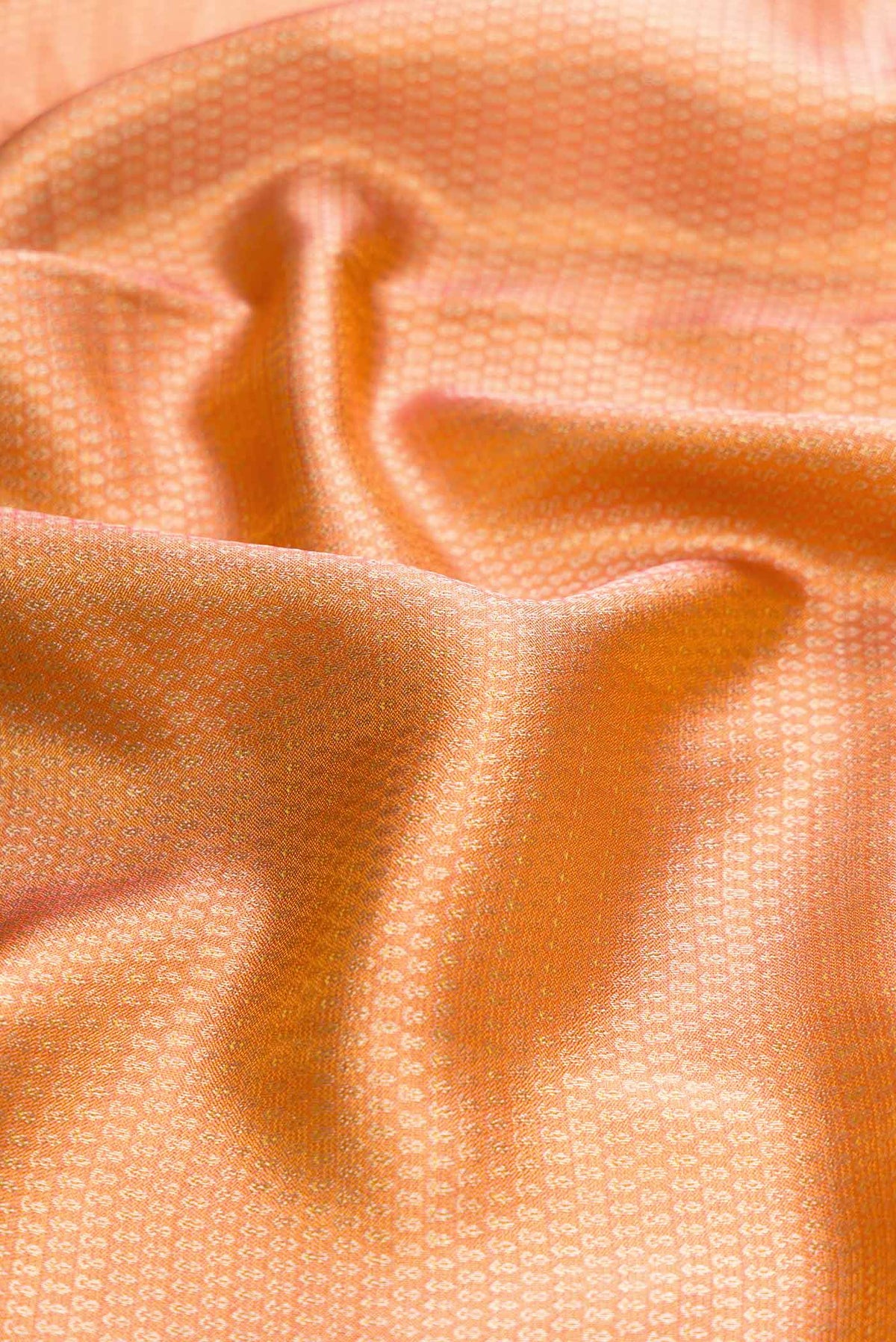 Close up of Orange Dual Tone Kanchipuram Tissue Silk Saree with Zari Brocade on the body and Zari Border displaying folds