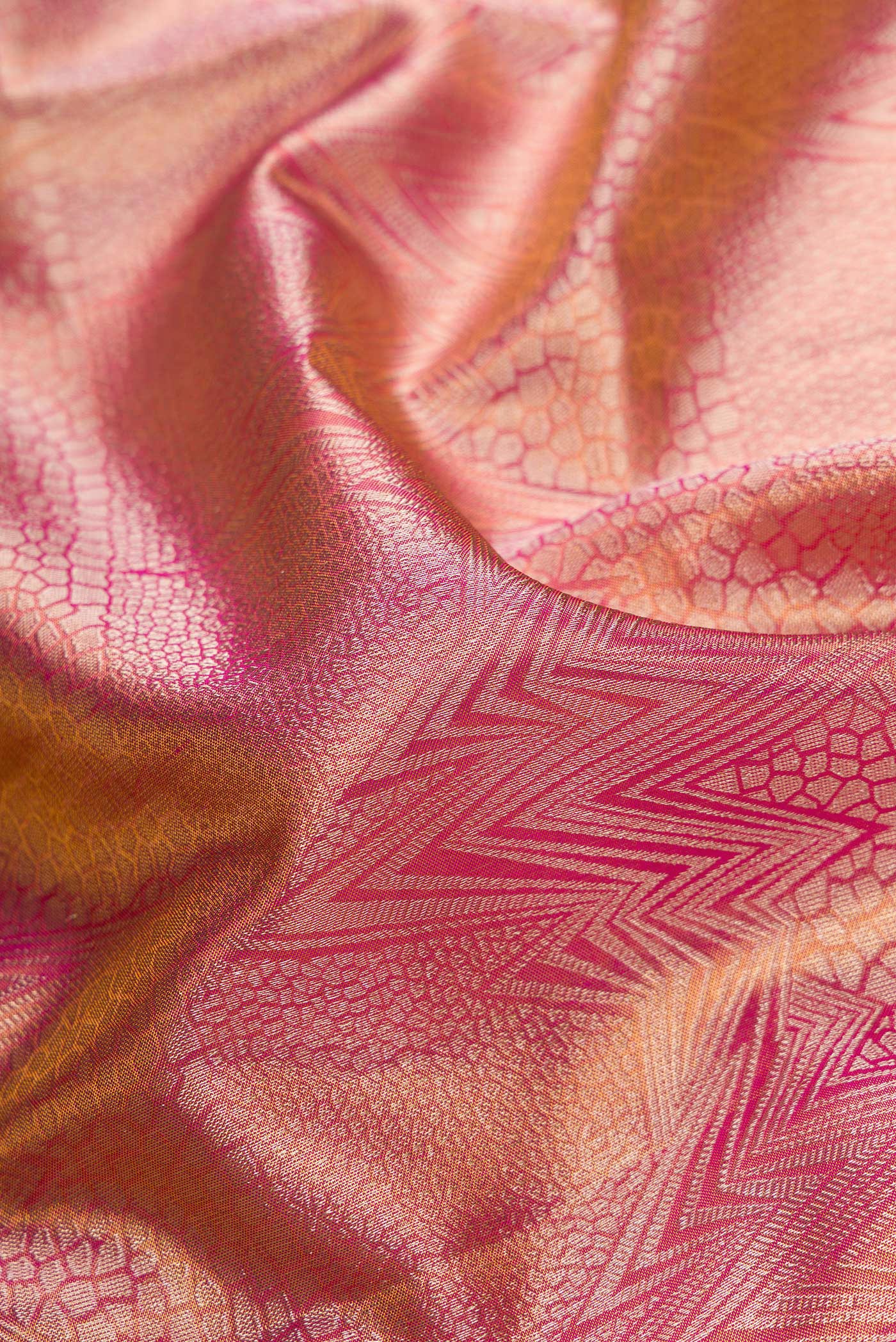 Close up of Rose Gold Dual Tone Kanchipuram Tissue Silk Saree with Zari Brocade on the body and Zari Border.  displaying folds