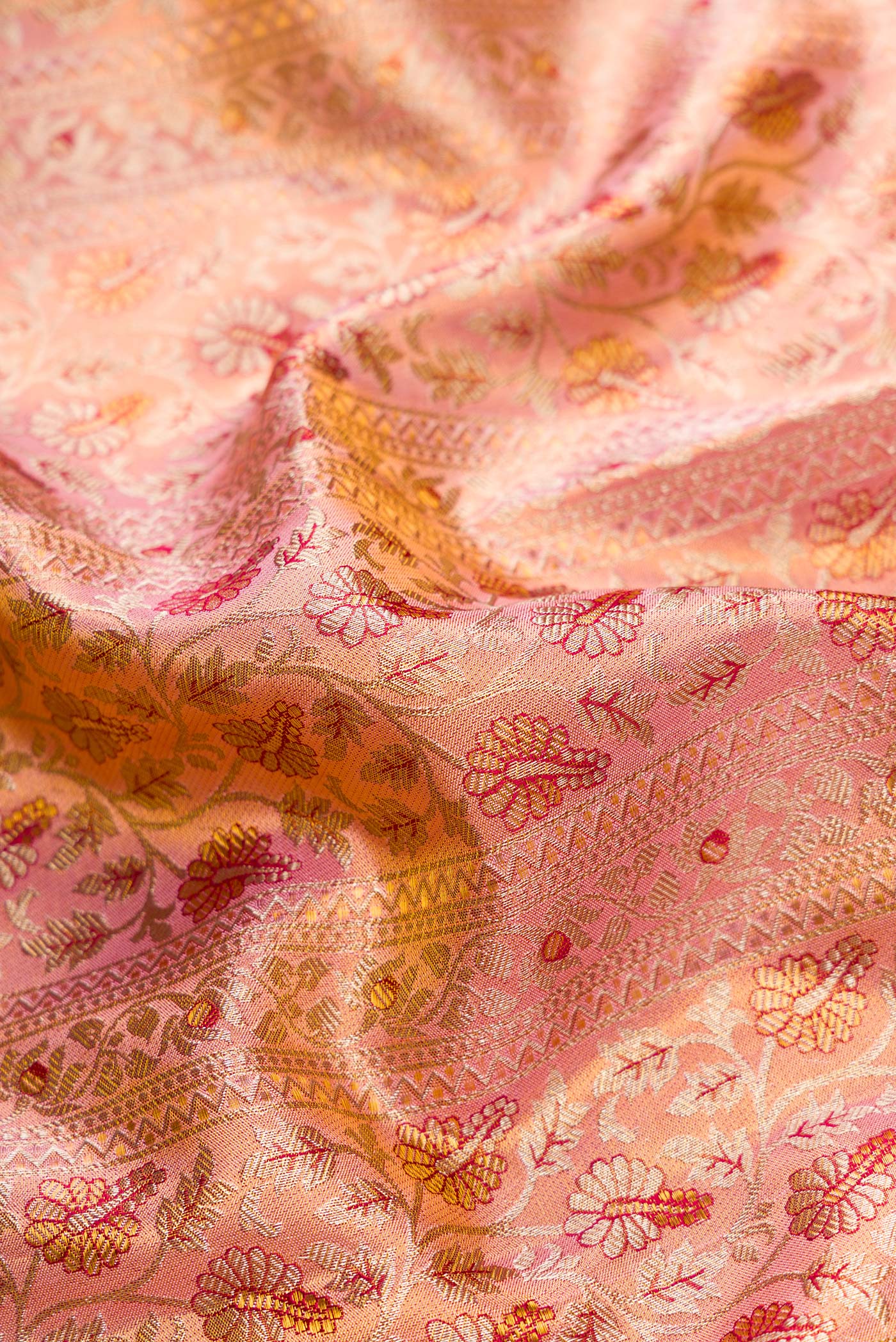 Close up of Golden Peach Dual Tone Kanchipuram Tissue Silk Saree with Zari Brocade on the body and Zari Border.  displaying folds