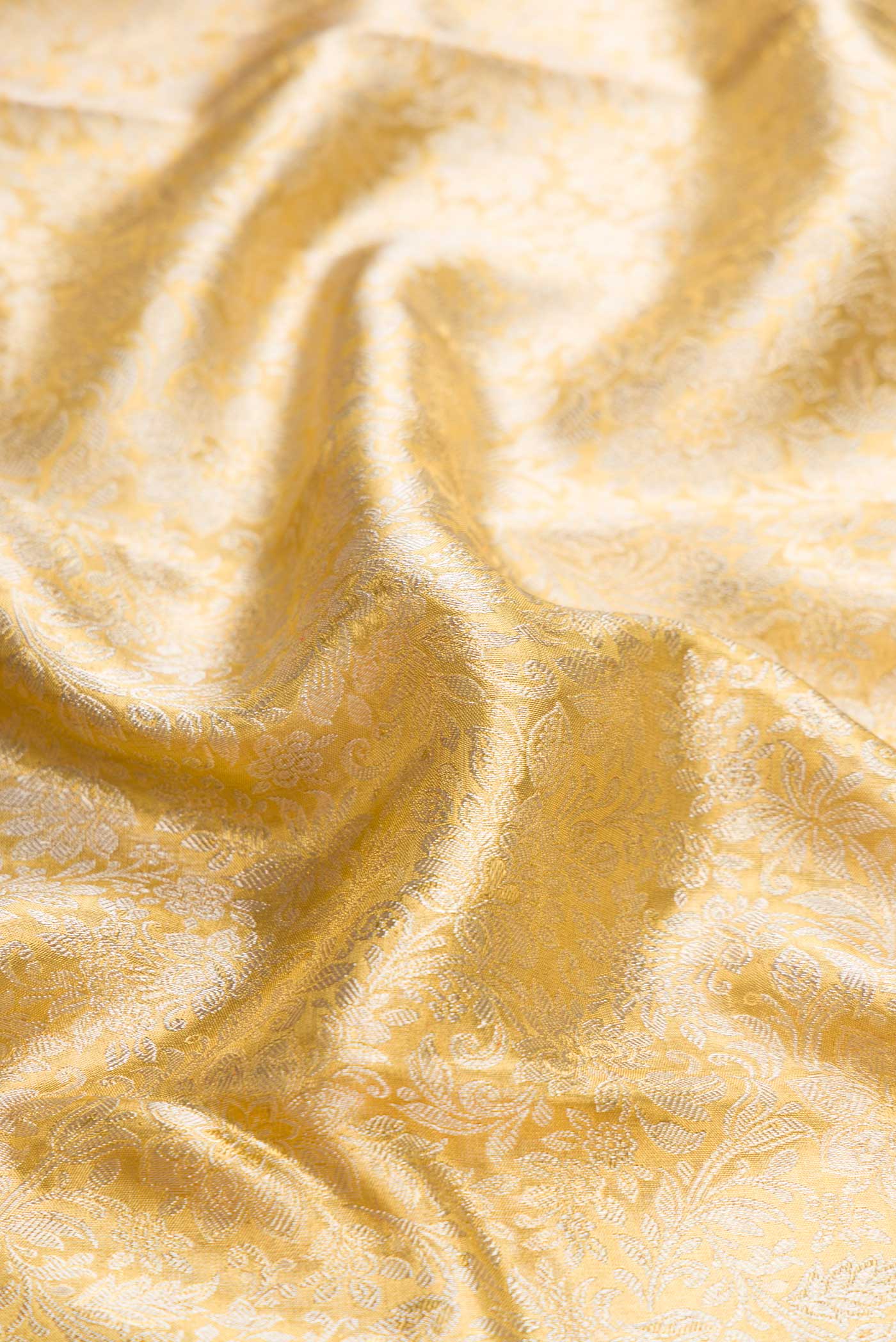 Close up of Pure Silk Pure Zari Gold Dual Tone Kanchipuram Tissue Saree with Zari Brocade on the body and Zari Border displaying folds
