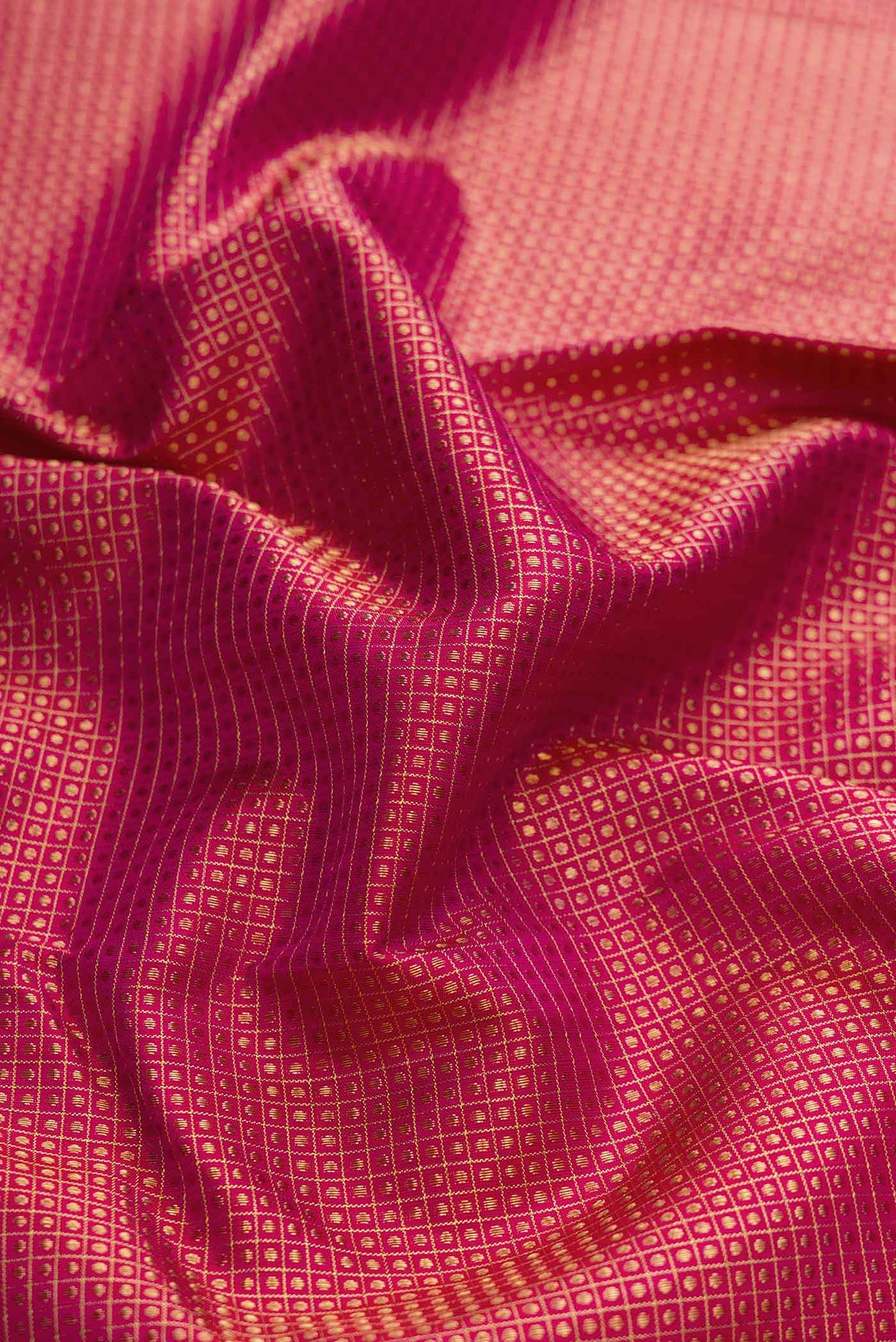 Close up of Pure Silk Pure Zari Magenta Dual Tone Kanchipuram Saree with Zari Brocade on the body and Zari Border displaying folds