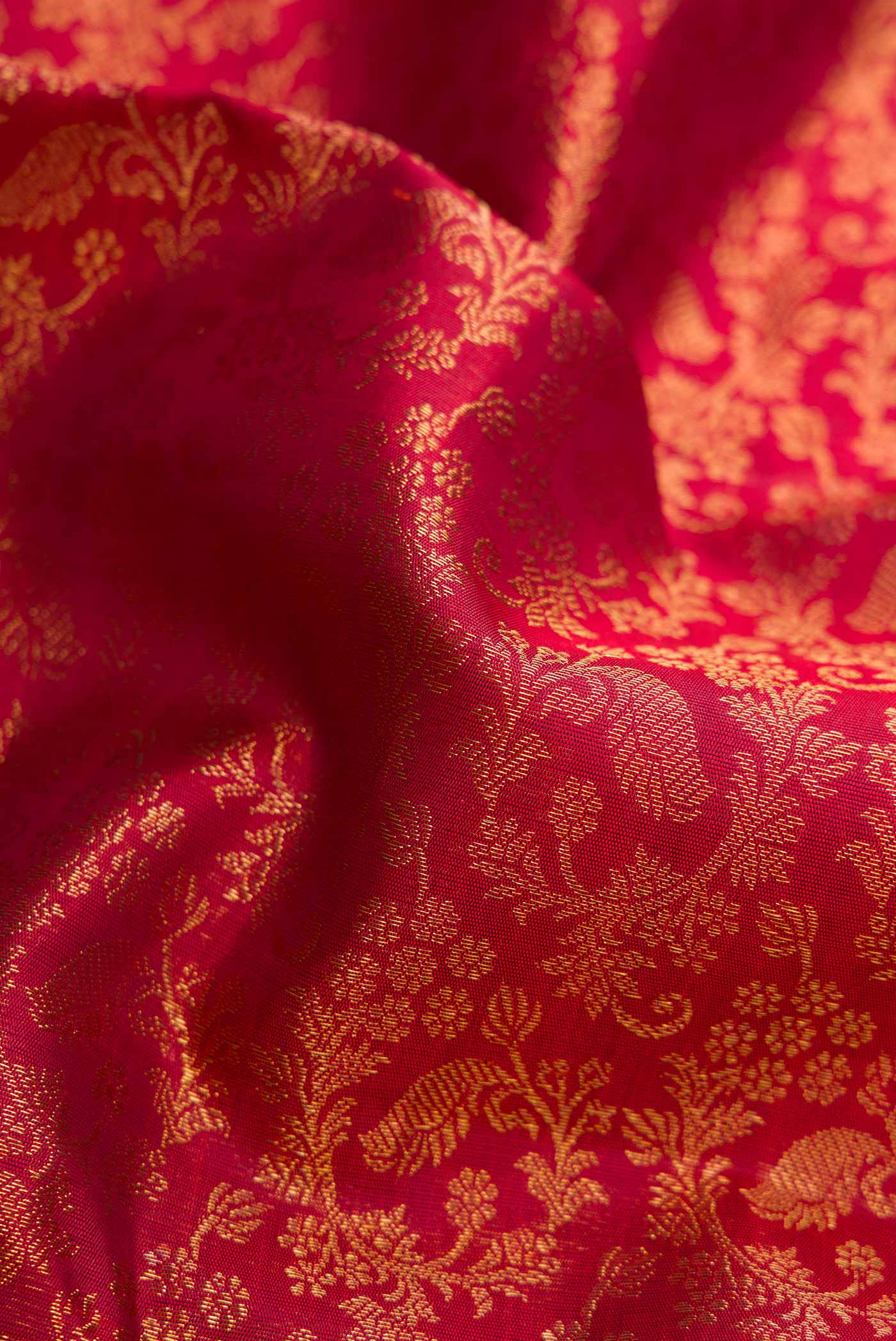 Close up of Pure Silk Pure Zari Maroon Dual Tone Kanjivaram Saree with Zari Brocade on the body and Zari Border.  displaying folds