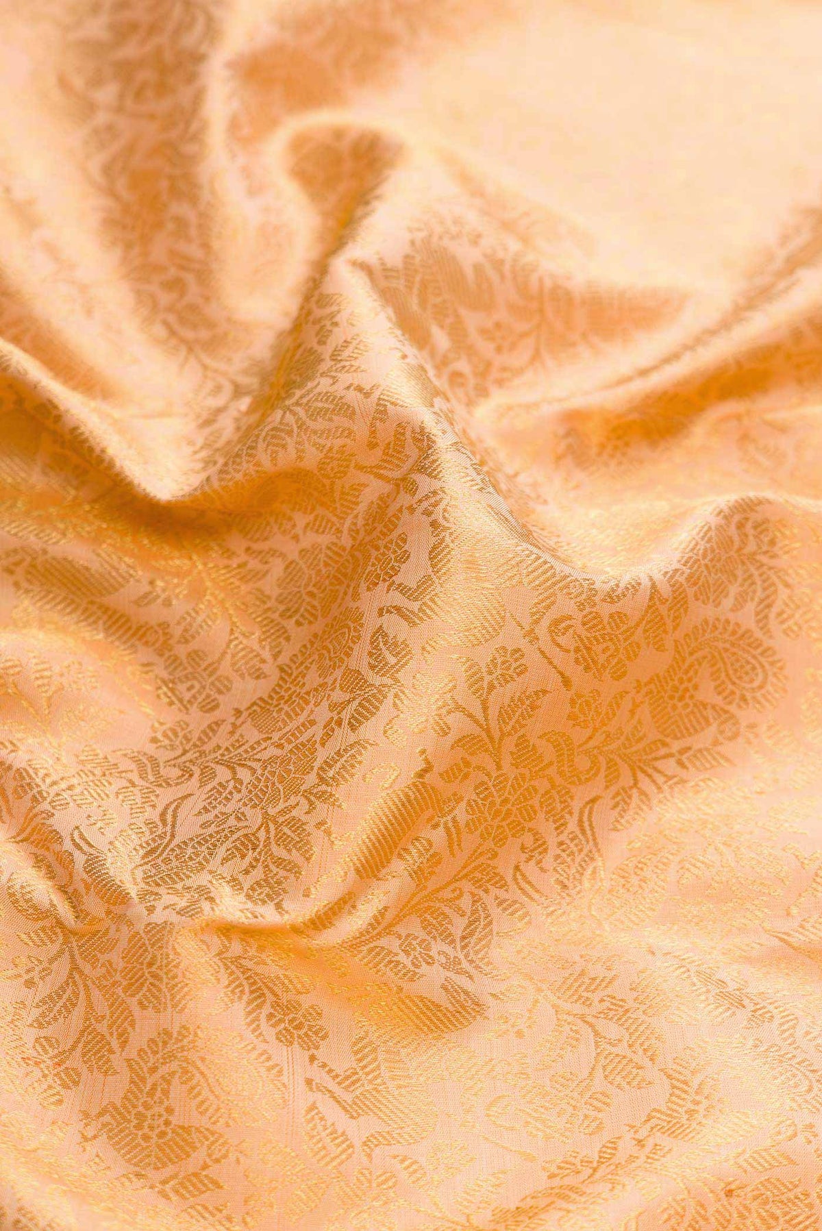 Close up of Pure Silk Pure Zari Golden Peach Dual Tone Kanchipuram Saree with Zari Brocade on the body and Zari Border displaying folds