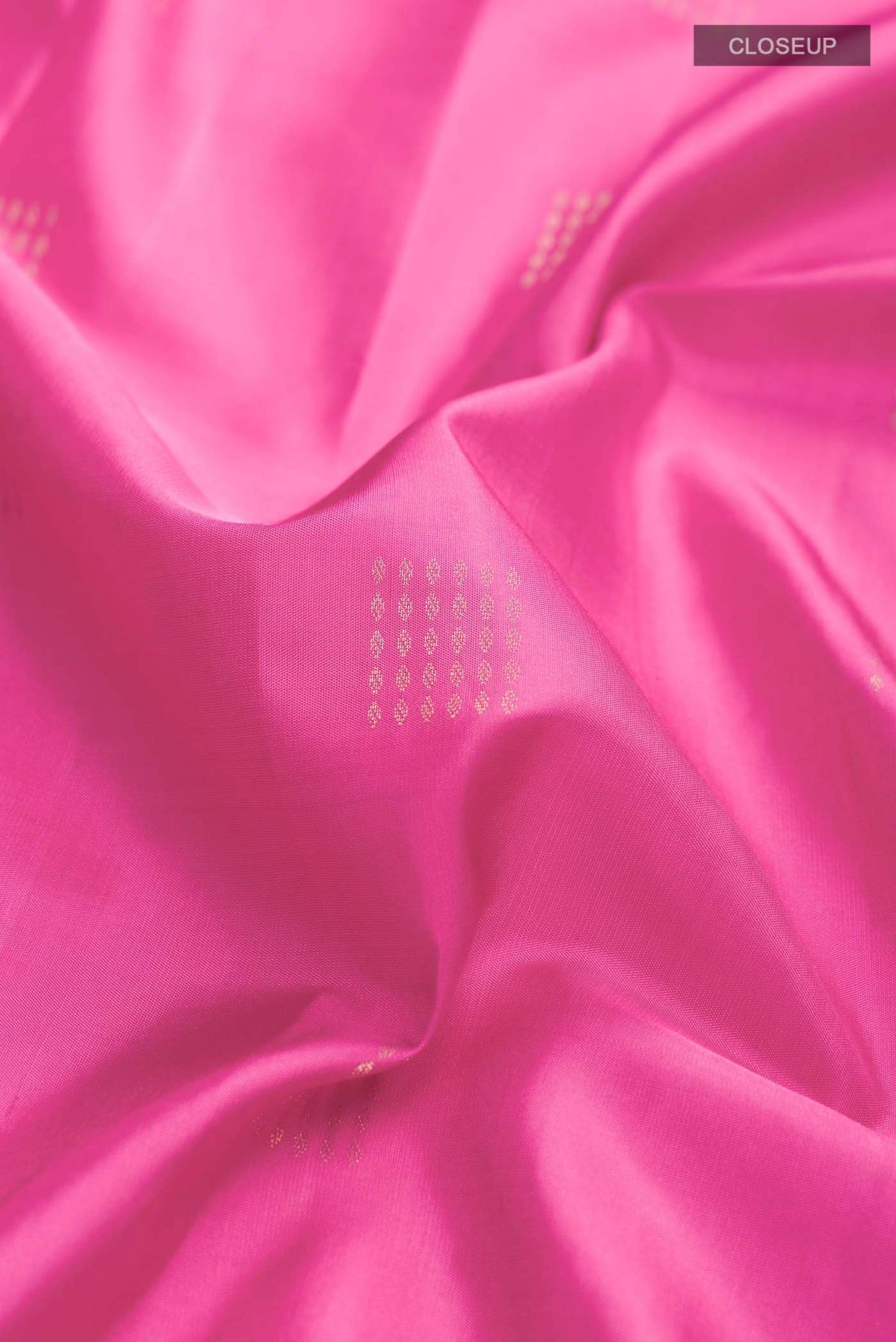 Close up of Pink Soft Silk Saree with Zari Butta on the body and Zari Border displaying folds