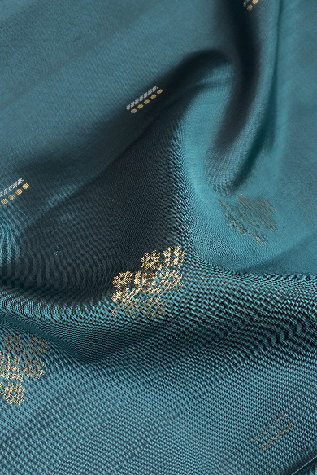 Close up of Pure Silk Green Soft Saree with Zari Butta on the body and Zari Border.  displaying folds