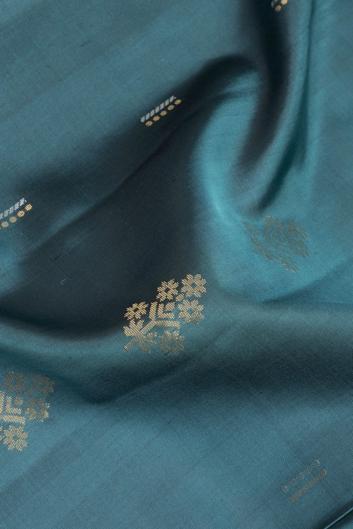Close up of Pure Silk Green Soft Saree with Zari Butta on the body and Zari Border.  displaying folds