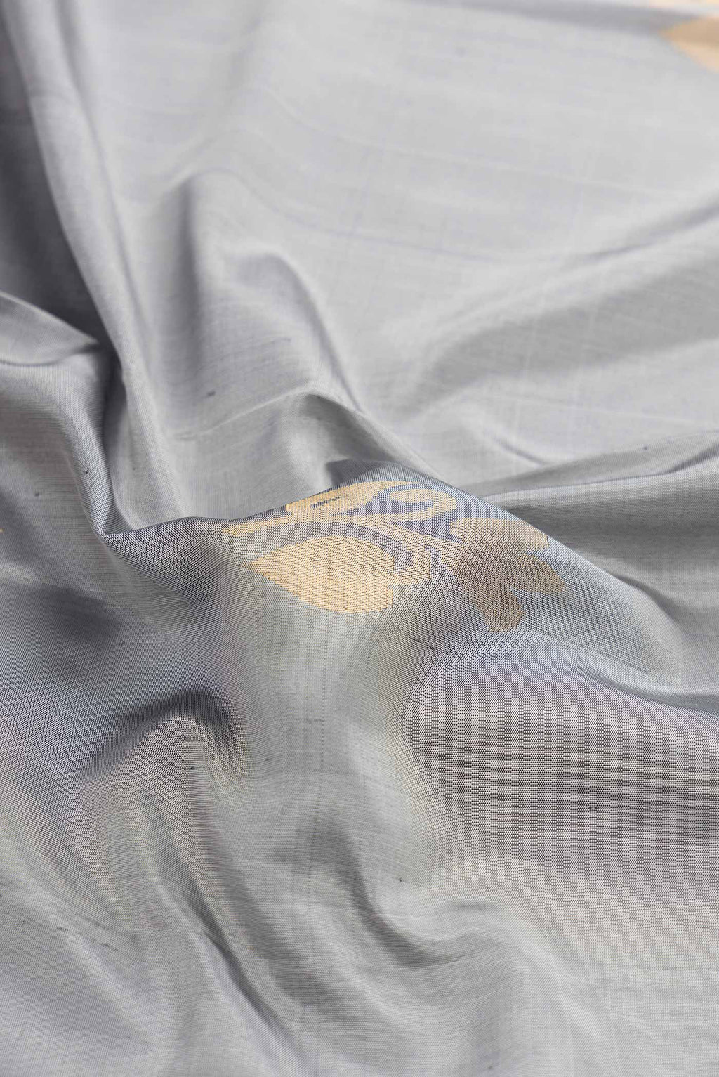 Close up of Grey Dual Tone Soft Silk Saree with Zari Butta on the body and Zari Border displaying folds