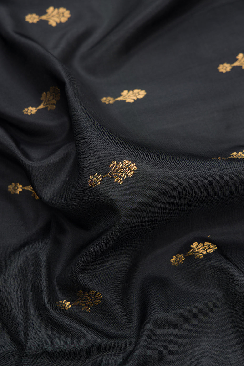 Close up of Black Dual Tone Soft Silk Saree with Zari Butta on the body and Zari Border.  displaying folds