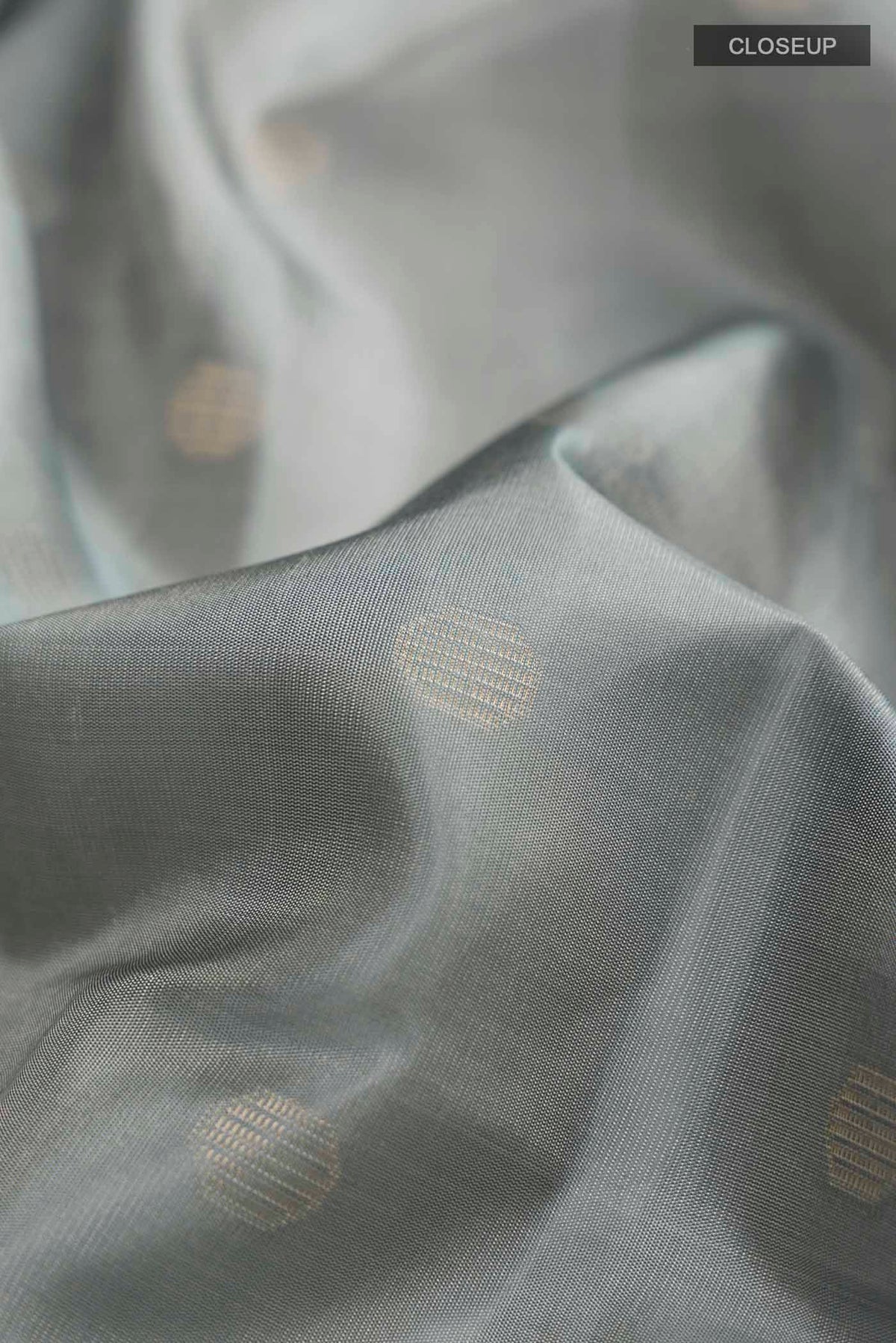 Close up of Grey Soft Silk Saree with Zari Butta on the body and Zari Border displaying folds