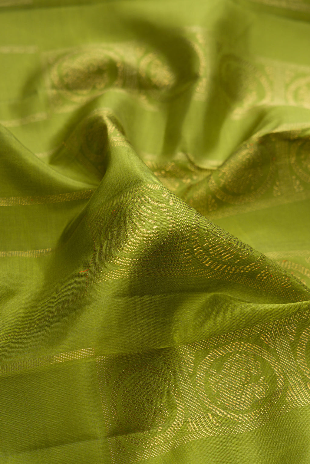 Close up of Pure Silk Pure Zari Green Dual Tone Kanjivaram Saree with Zari Butta on the body and Without Border.  displaying folds