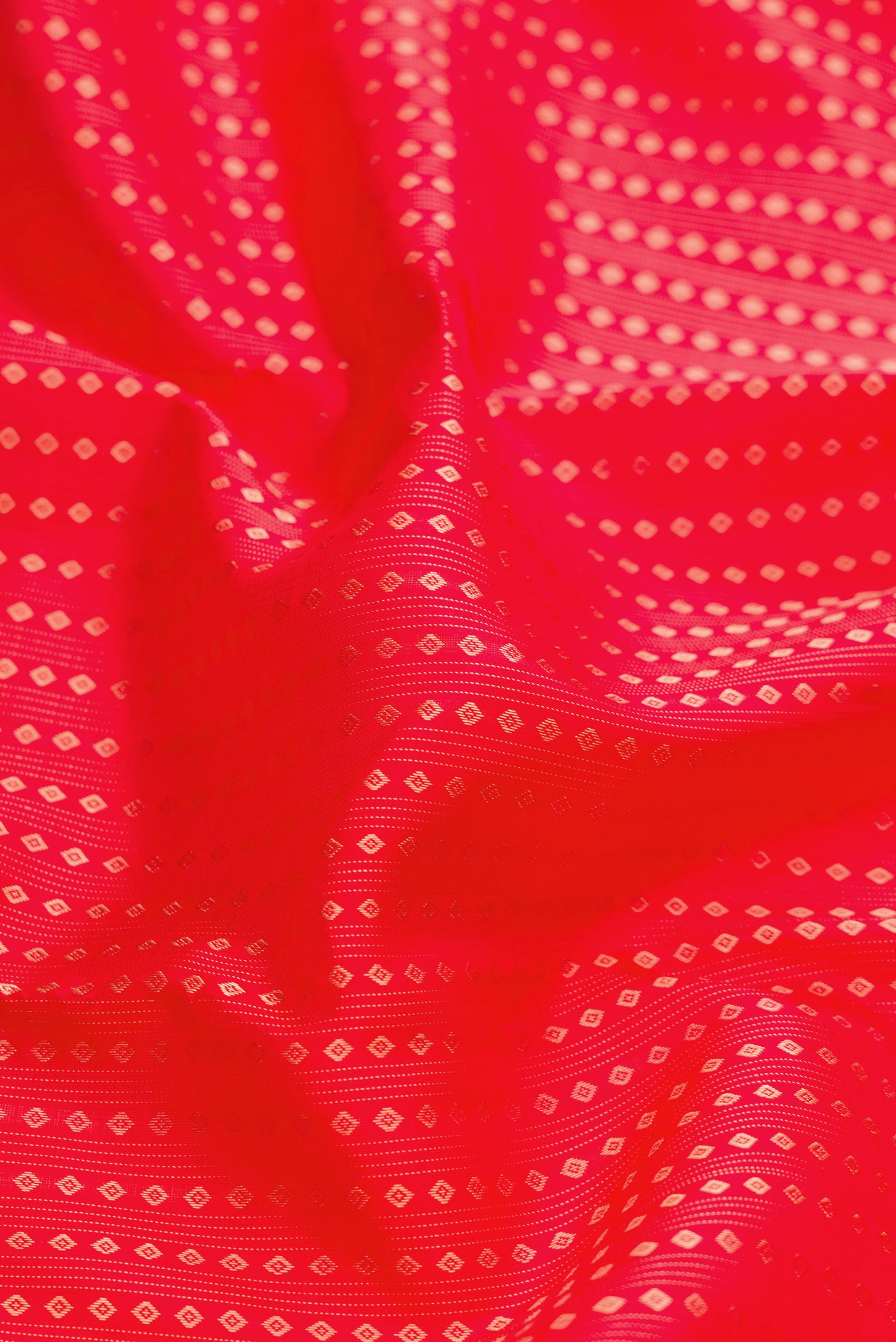 Close up of Red Dual Tone Kanjivaram Silk Saree with Stripes on the body and Without Border.  displaying folds