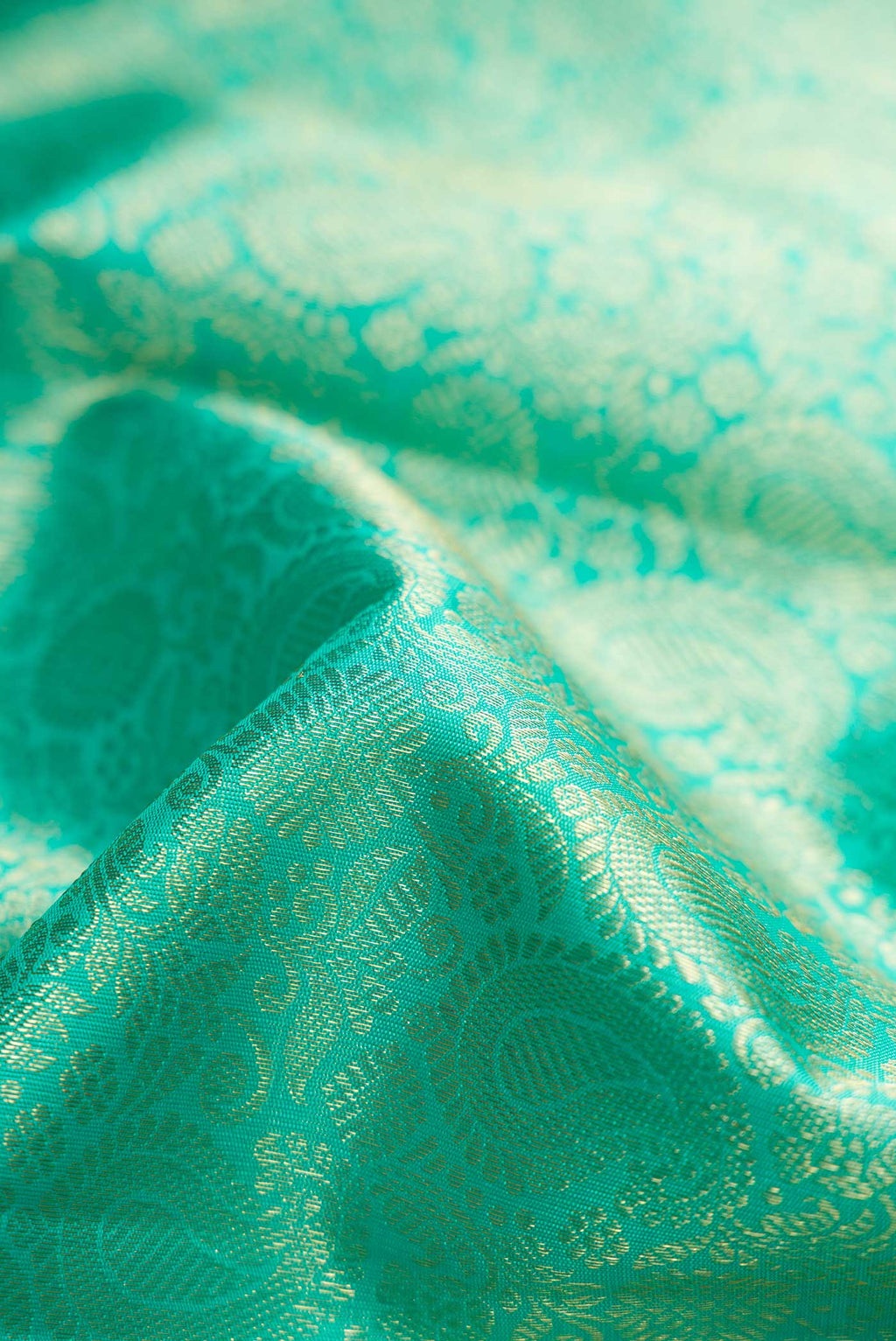 Close up of Pure Silk Pure Zari Sea Green Dual Tone Kanchipuram Saree with Zari Brocade on the body and Zari Border displaying folds