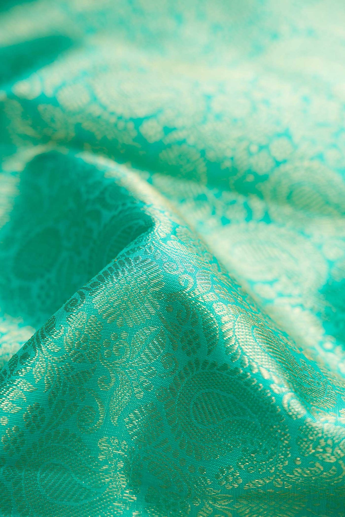Close up of Pure Silk Pure Zari Sea Green Dual Tone Kanchipuram Saree with Zari Brocade on the body and Zari Border displaying folds
