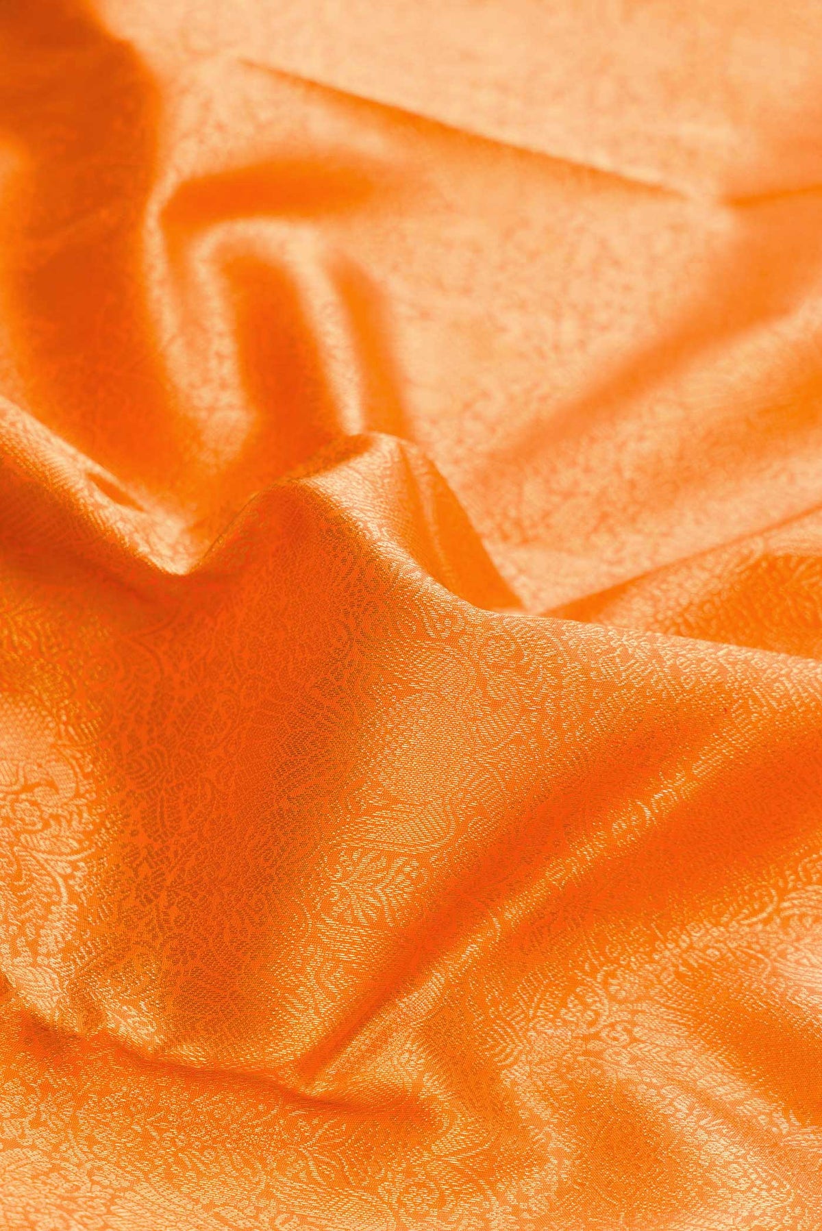 Close up of Pure Silk Pure Zari Orange Dual Tone Kanchipuram Saree with Zari Brocade on the body and Zari Border displaying folds