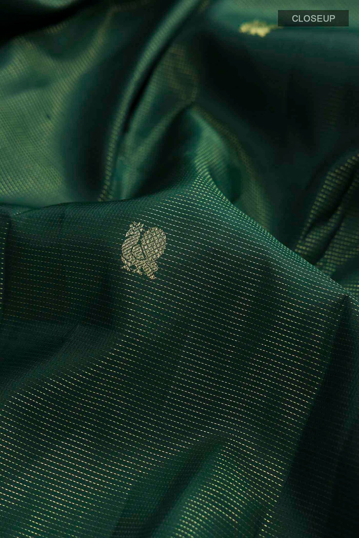 Close up of Green Kanchipuram Silk Saree with Zari Butta on the body and Zari Border displaying folds