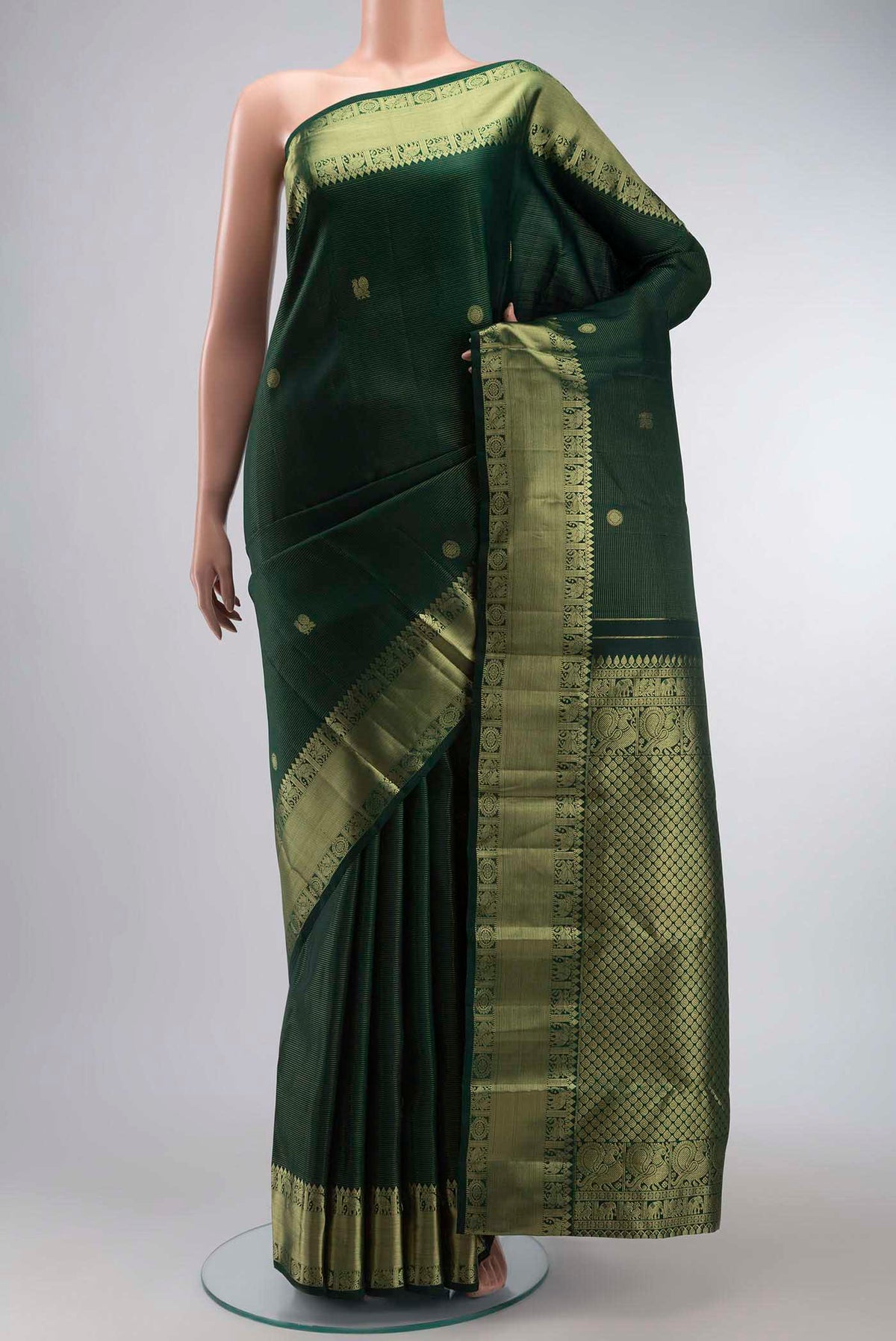 Green Kanchipuram Silk Saree with Zari Butta on the body and Zari Border displayed on a mannequin