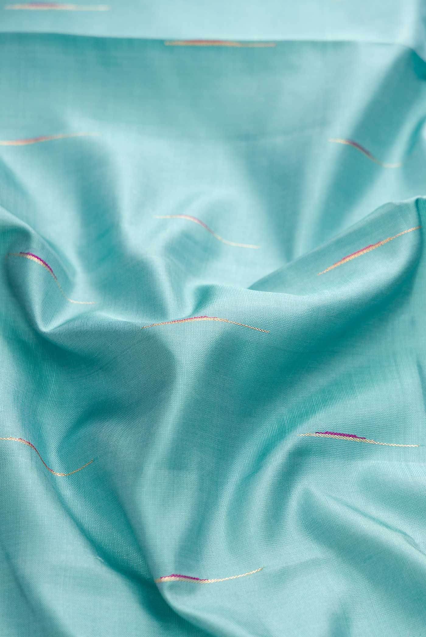 Close up of Blue Grey Dual Tone Kanchipuram Silk Saree with Zari Butta on the body and Zari Border displaying folds