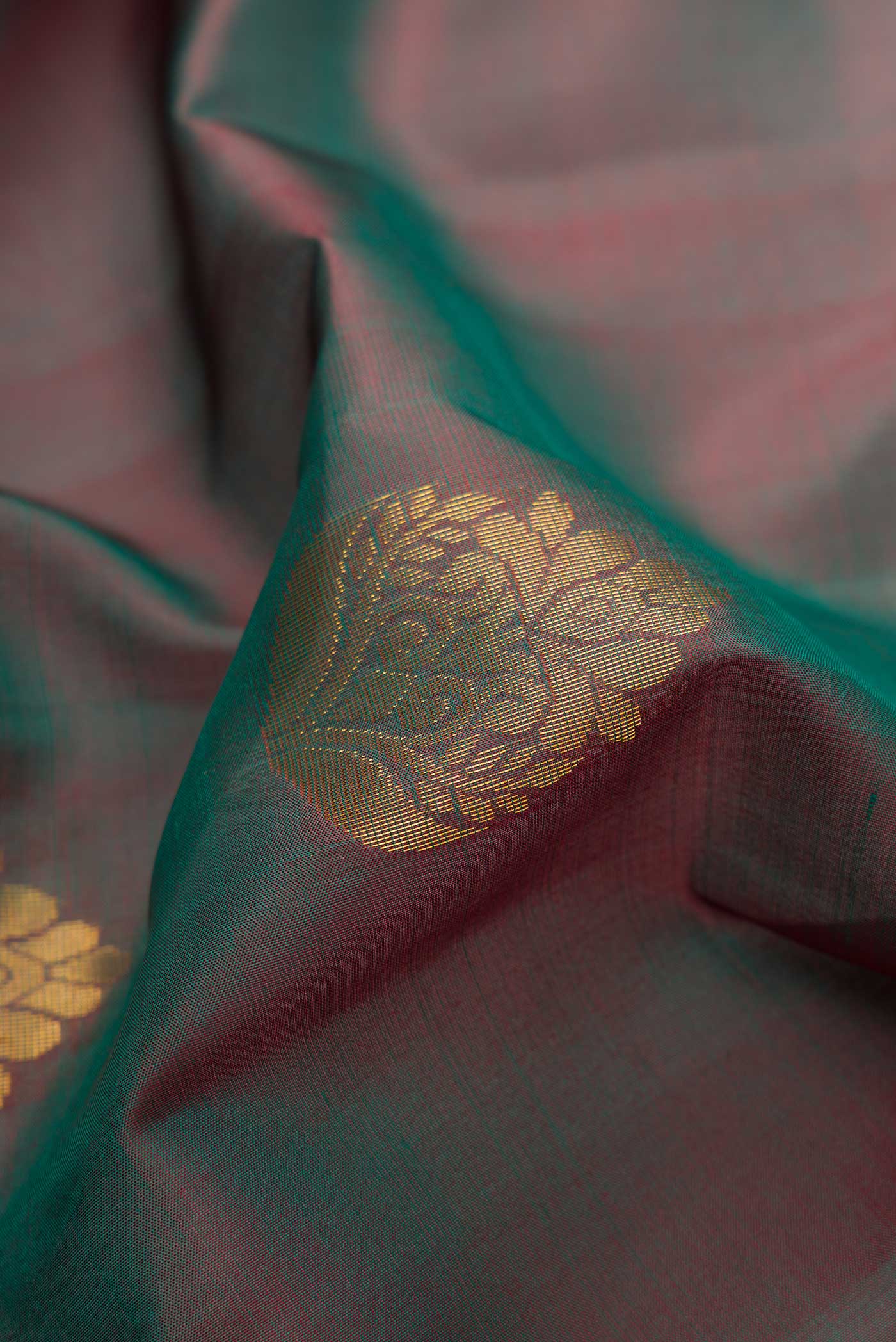 Close up of Bottle Green Dual Tone Soft Silk Saree with Zari Butta on the body and Fancy Border.  displaying folds