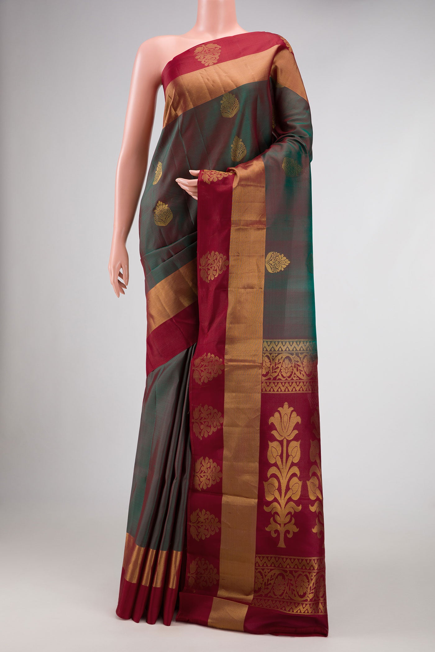 Bottle Green Dual Tone Soft Silk Saree with Zari Butta on the body and Fancy Border.  displayed on a mannequin