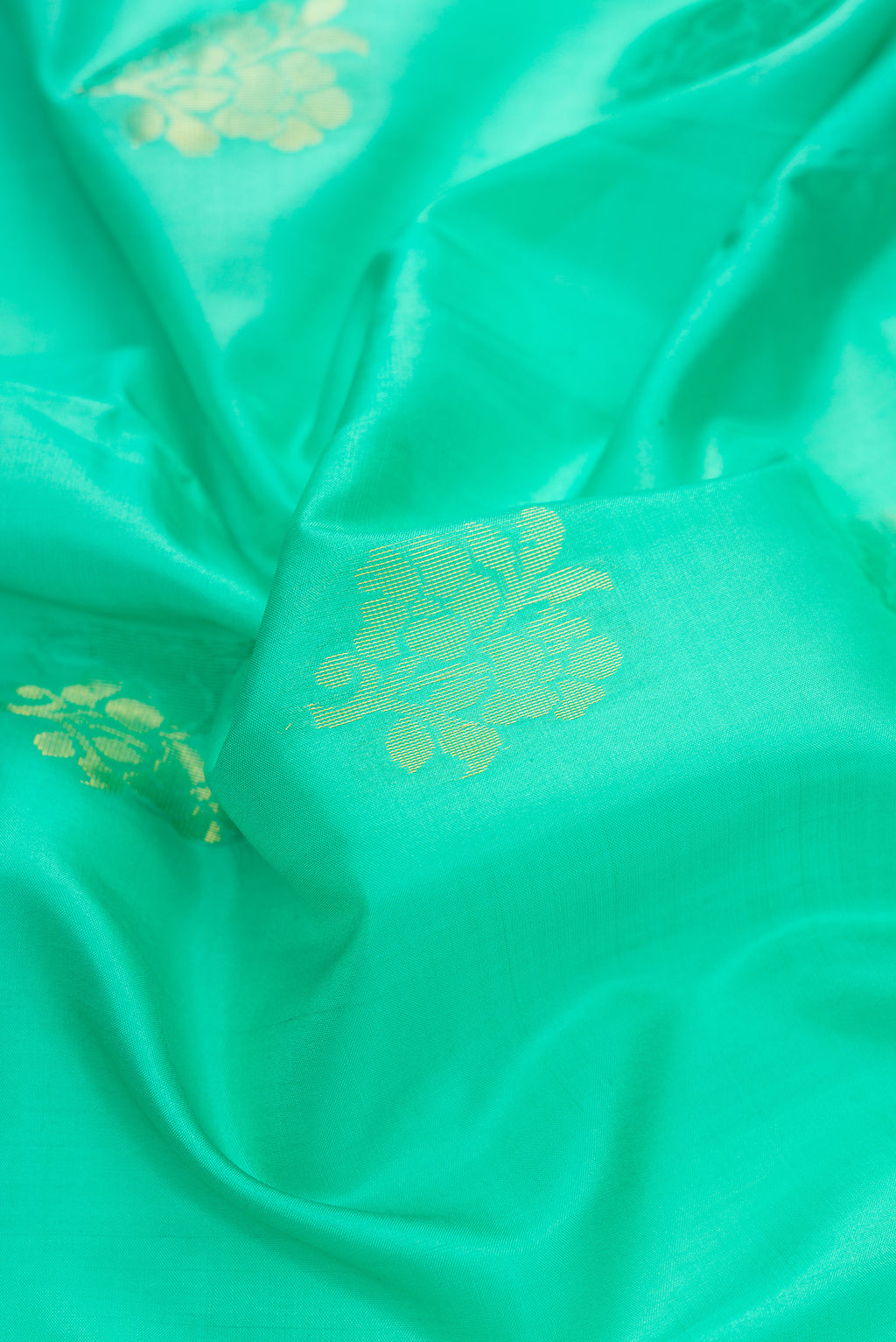 Close up of Sea Green Dual Tone Soft Silk Saree with Zari Butta on the body and Fancy Border.  displaying folds