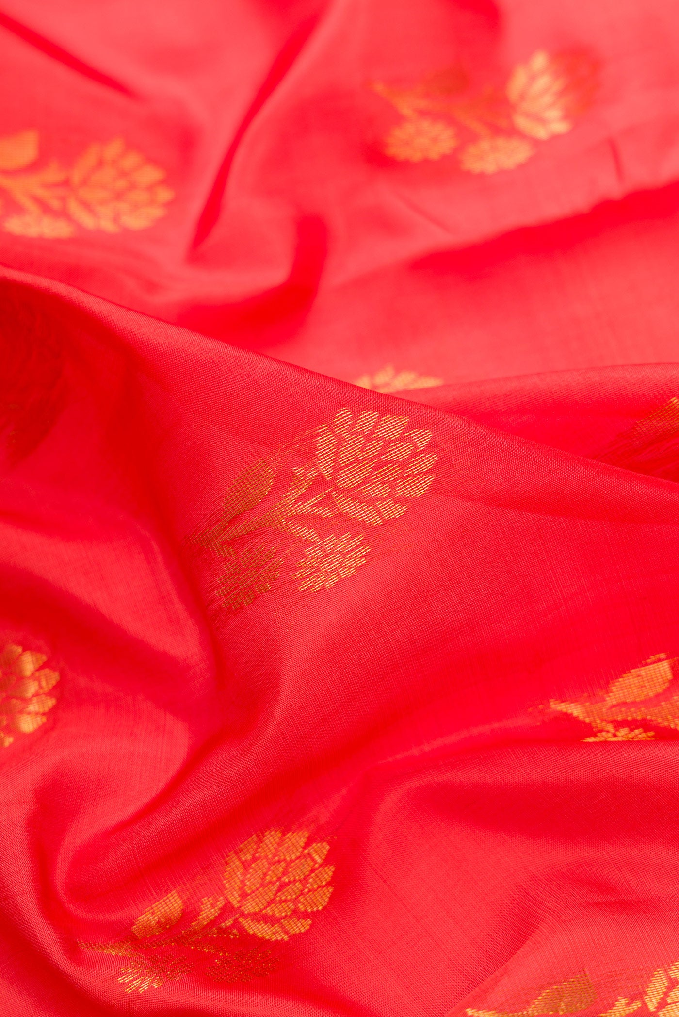Close up of Orange Dual Tone Soft Silk Saree with Zari Butta on the body and Fancy Border.  displaying folds