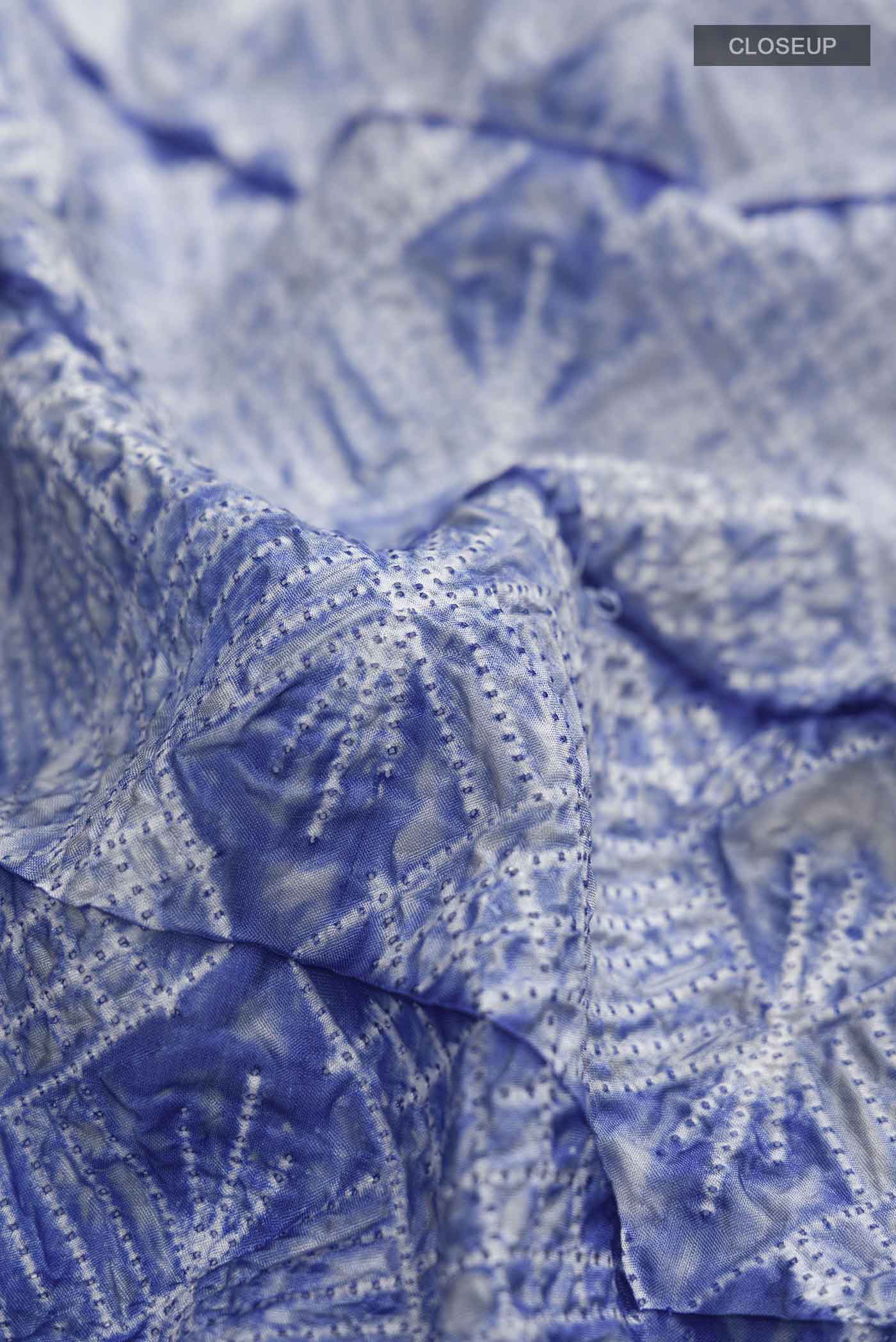 Close up of Blue Tussar Silk Saree Printed design on the body and Printed Border displaying folds