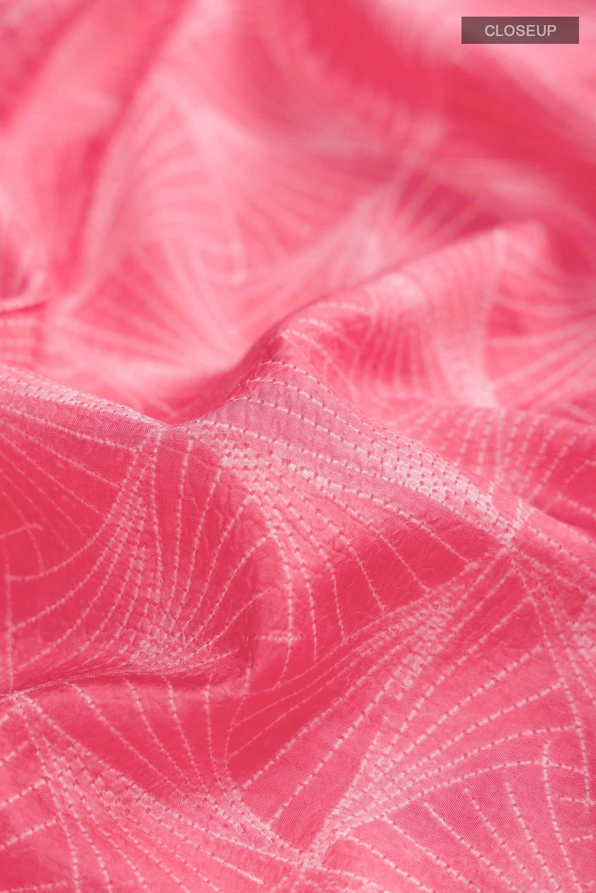 Close up of Coral Printed Silk SareePrinted design on the body and Printed Border displaying folds