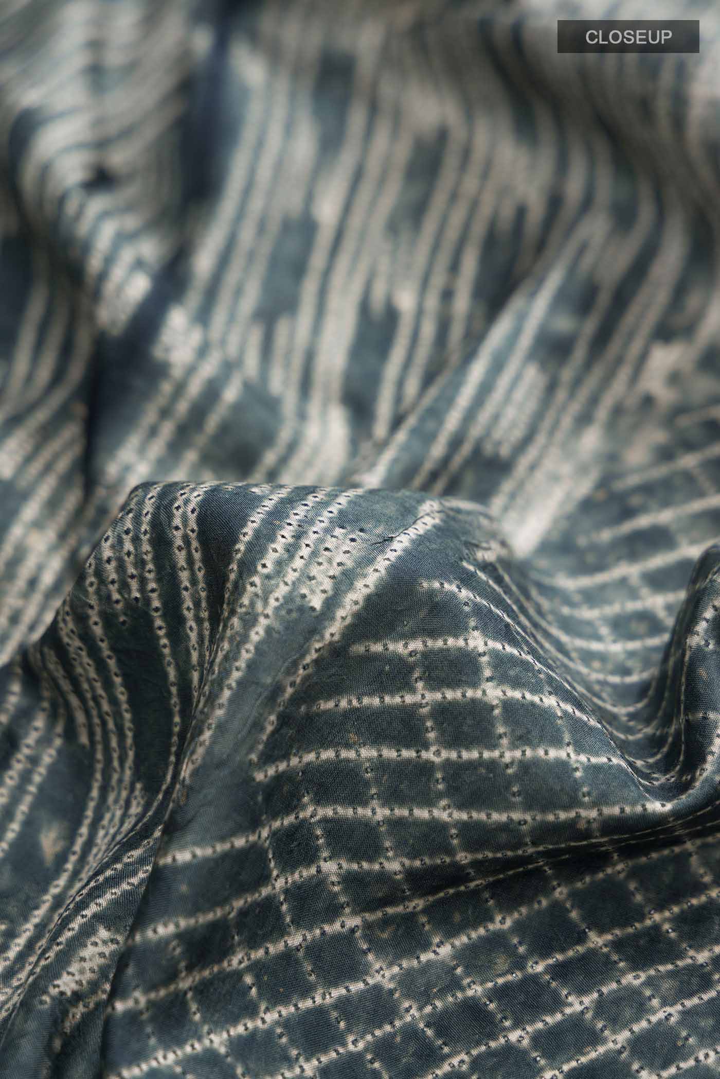 Close up of Grey Printed Silk SareePrinted design on the body and Printed Border displaying folds