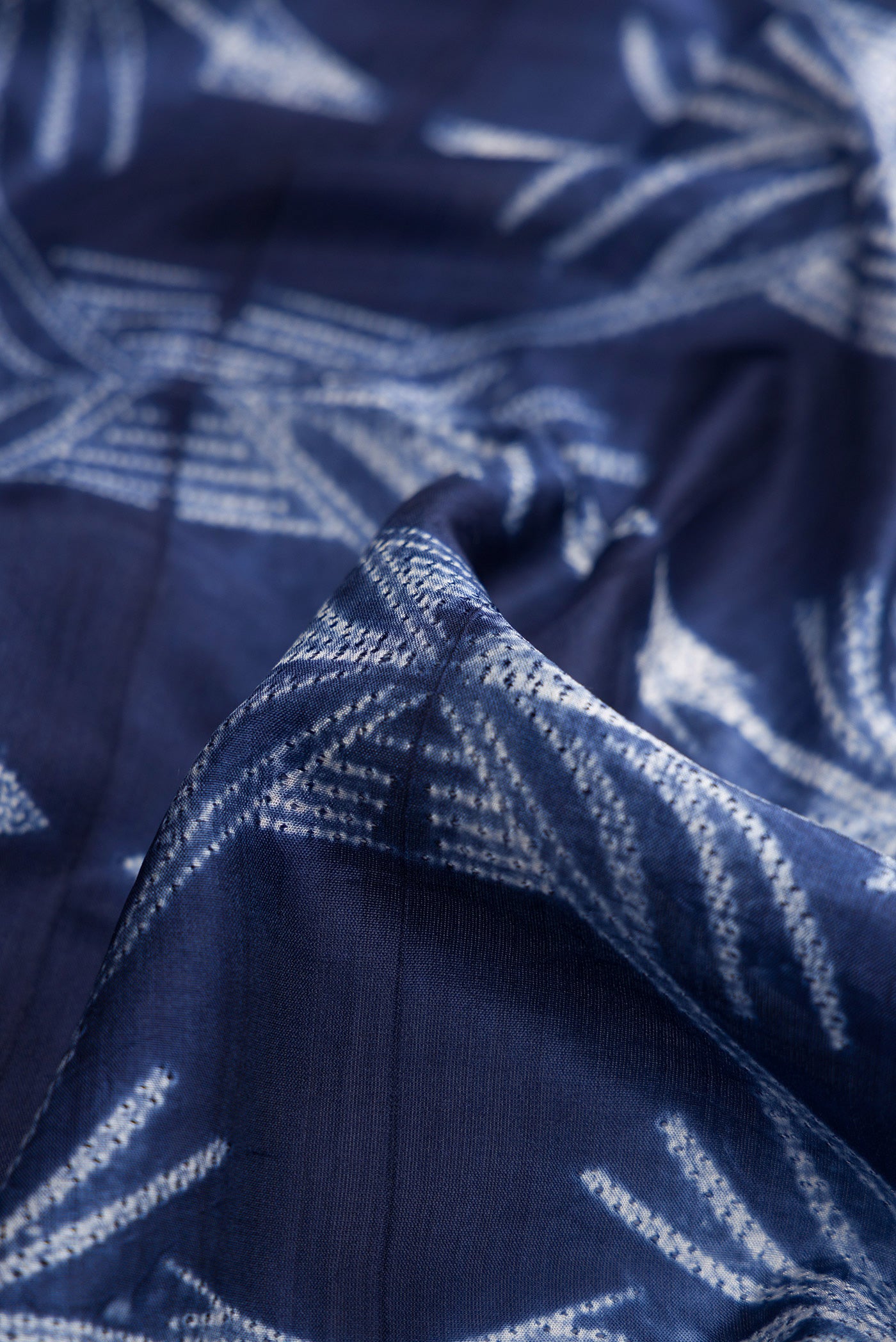 Close up of Navy Blue Dual Tone Tussar Silk Saree with Printed design on the body and Plain Border.  displaying folds