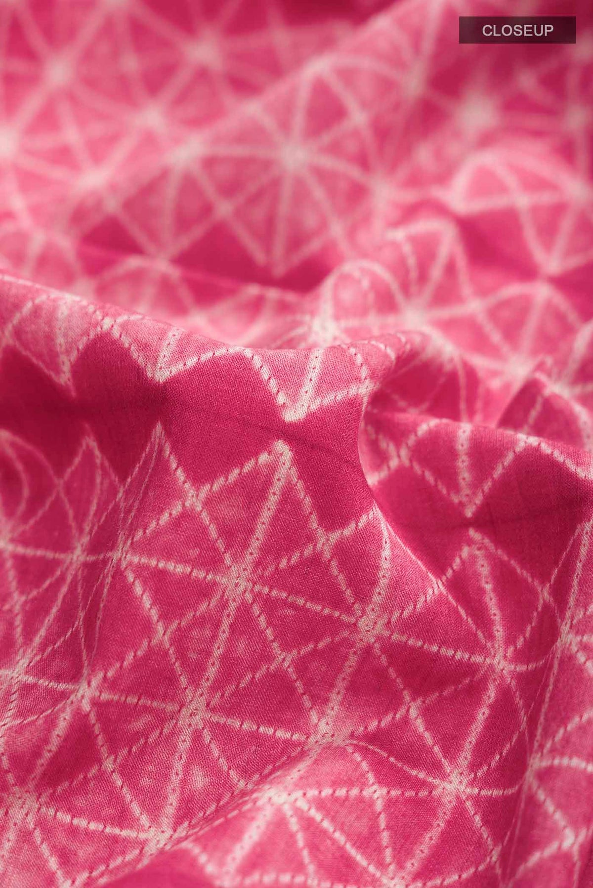 Close up of Red Tussar Silk Saree Printed design on the body and Plain Border displaying folds